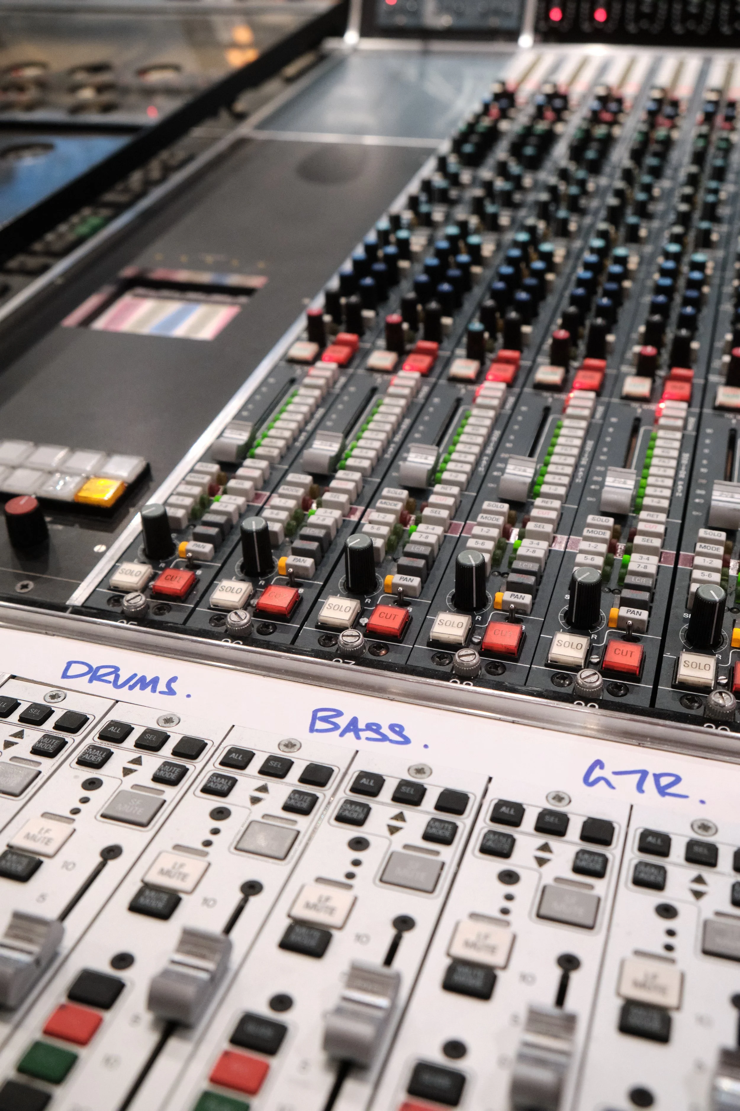 Table de mixage audio avec des réglages pour drums, bass et GTR, avec des notes écrites à la main.