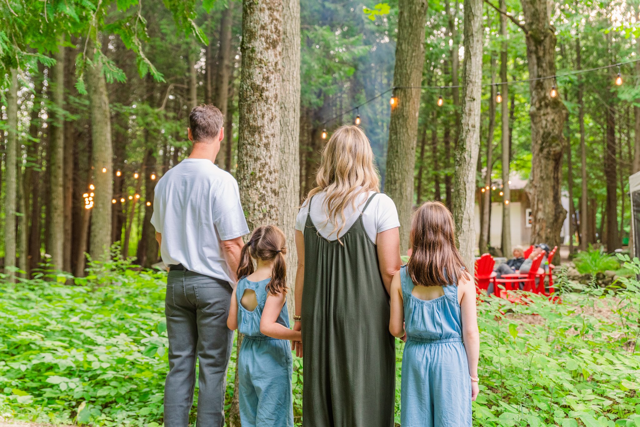 photo of woman, man, and 2 children looking out into the forest