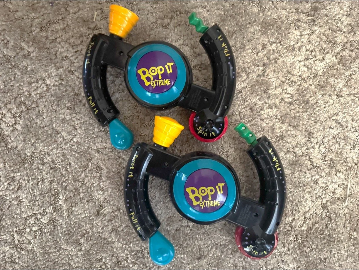 According to some Bop Diva viewer feedback, there are actually two releases of the original Bop It Extreme; one is from 1999 (top), and the other is from 2000 (bottom). You can tell the difference between them because the dot in the letter 'O' is sli