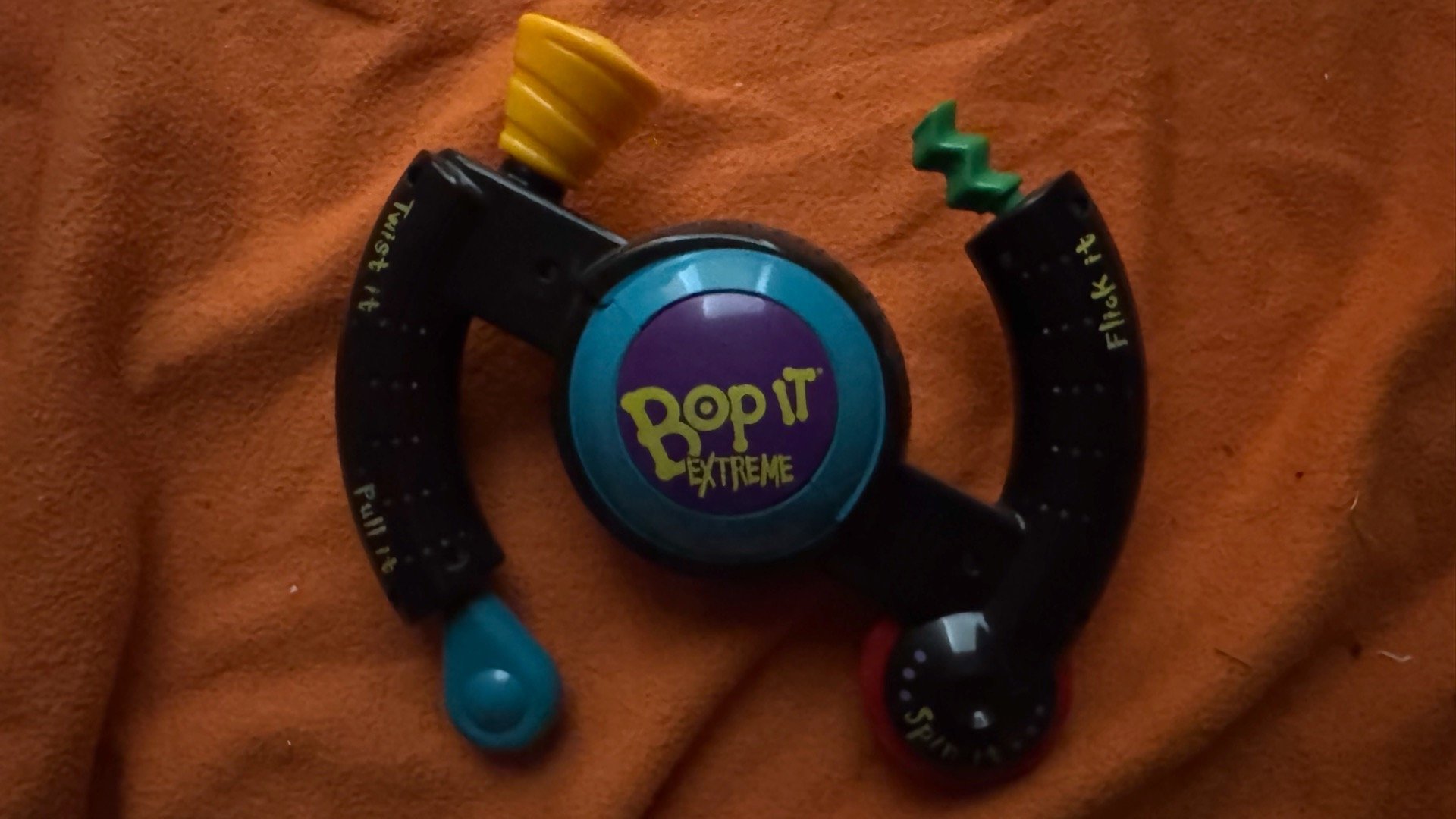 Name: Bop It Extreme  •  Version 2.0  •  Release Year: 2000  •  Revision Number: 64  •  Changes: Dot in 'O' on button is slightly smaller, otherwise no known internal changes