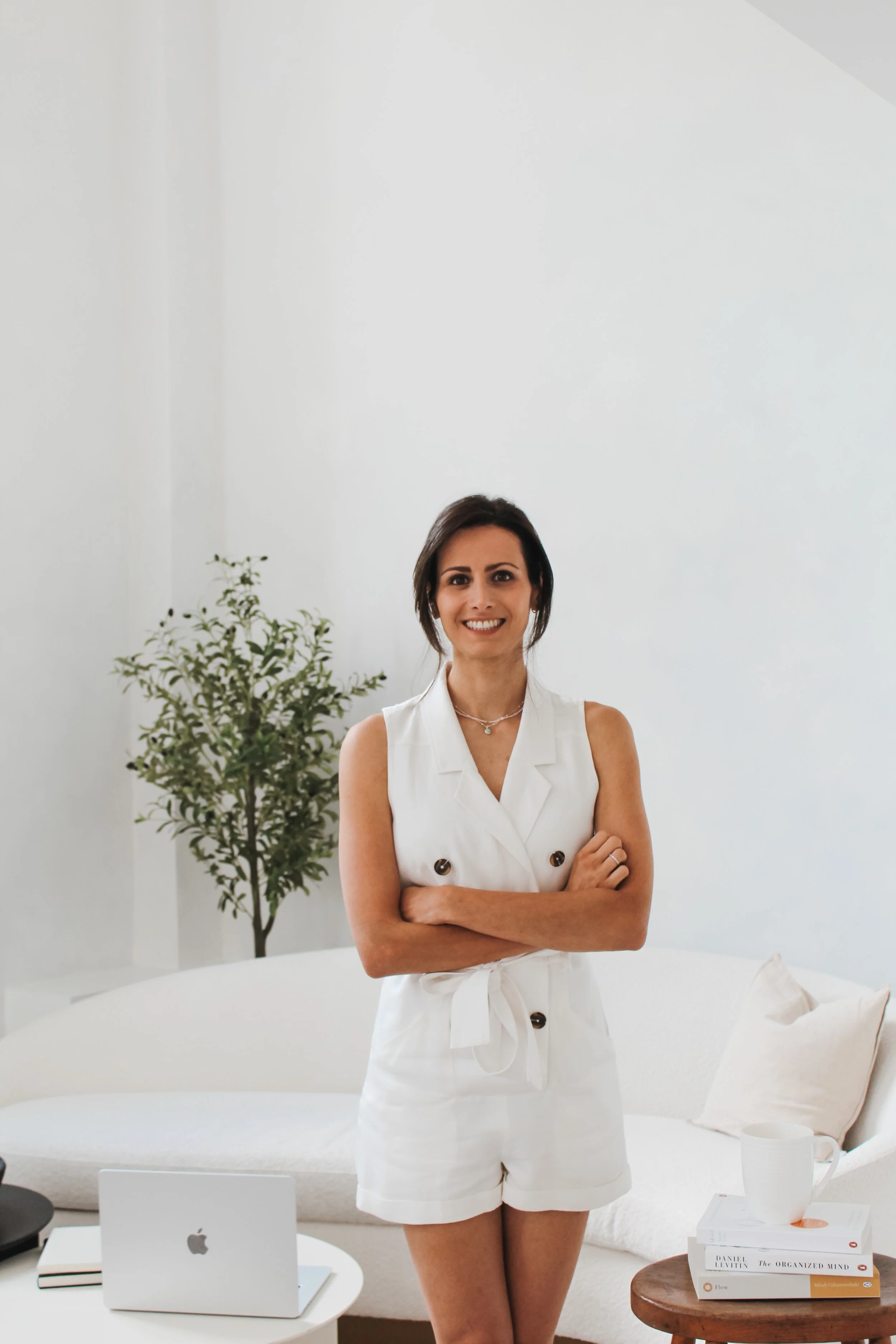 Photo of Shaady Harrison with her arms crossed standing in a white room.