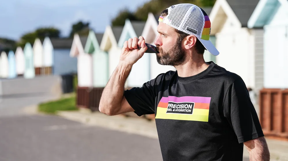Athlete drinking from a Precision Fuel & Hydration bottle