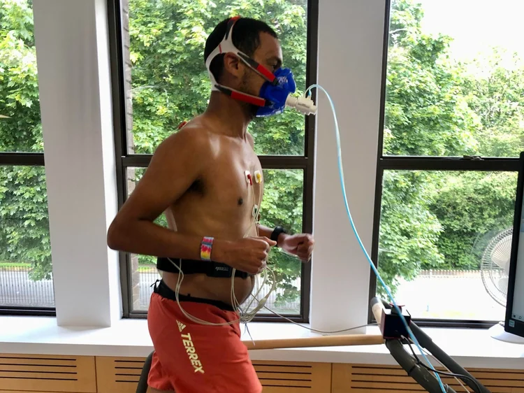 Athlete running on a treadmill with a breathing mask during a fuelling test