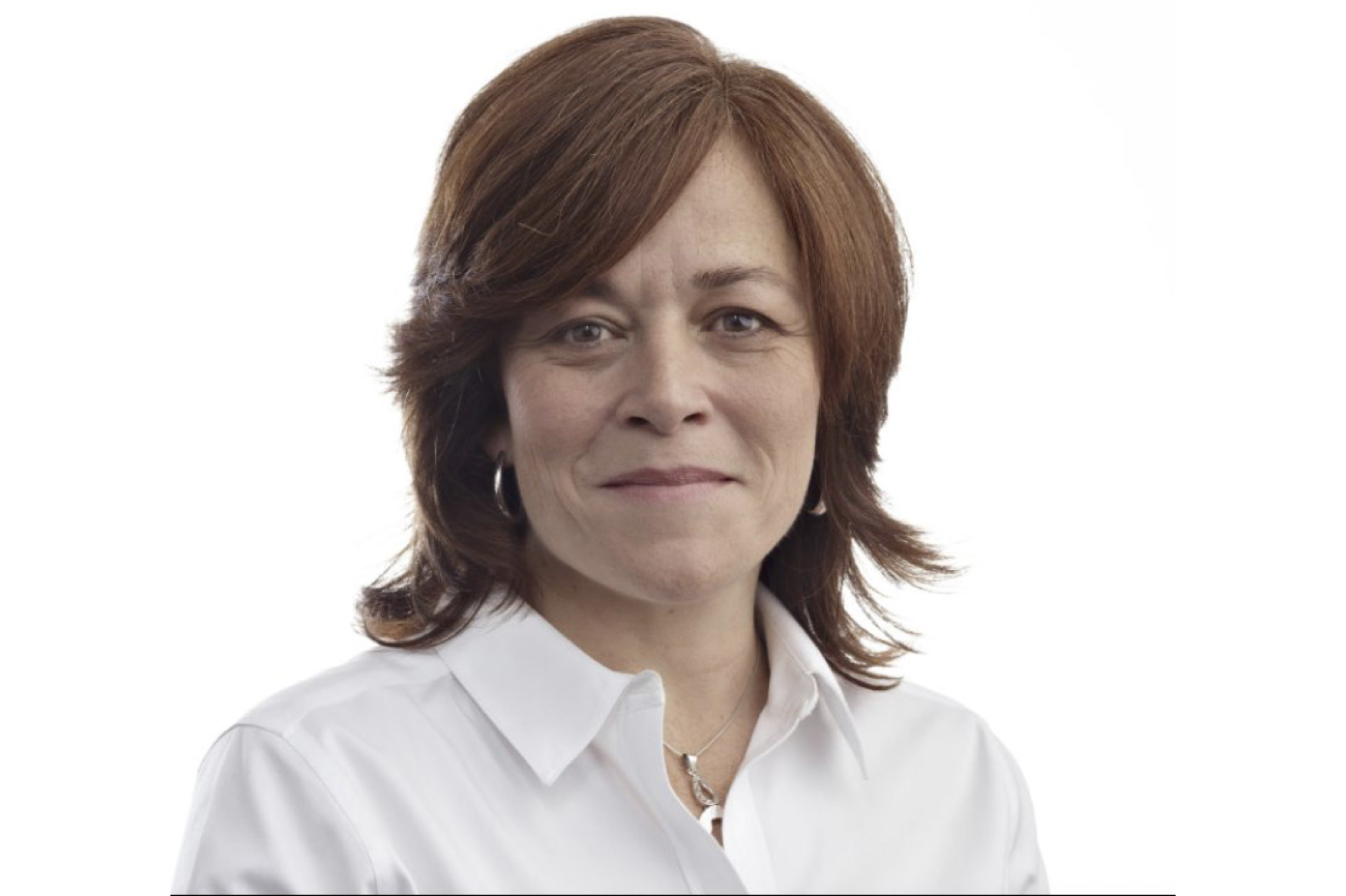 Woman with short brown hair wearing a white shirt and silver earrings, smiling.