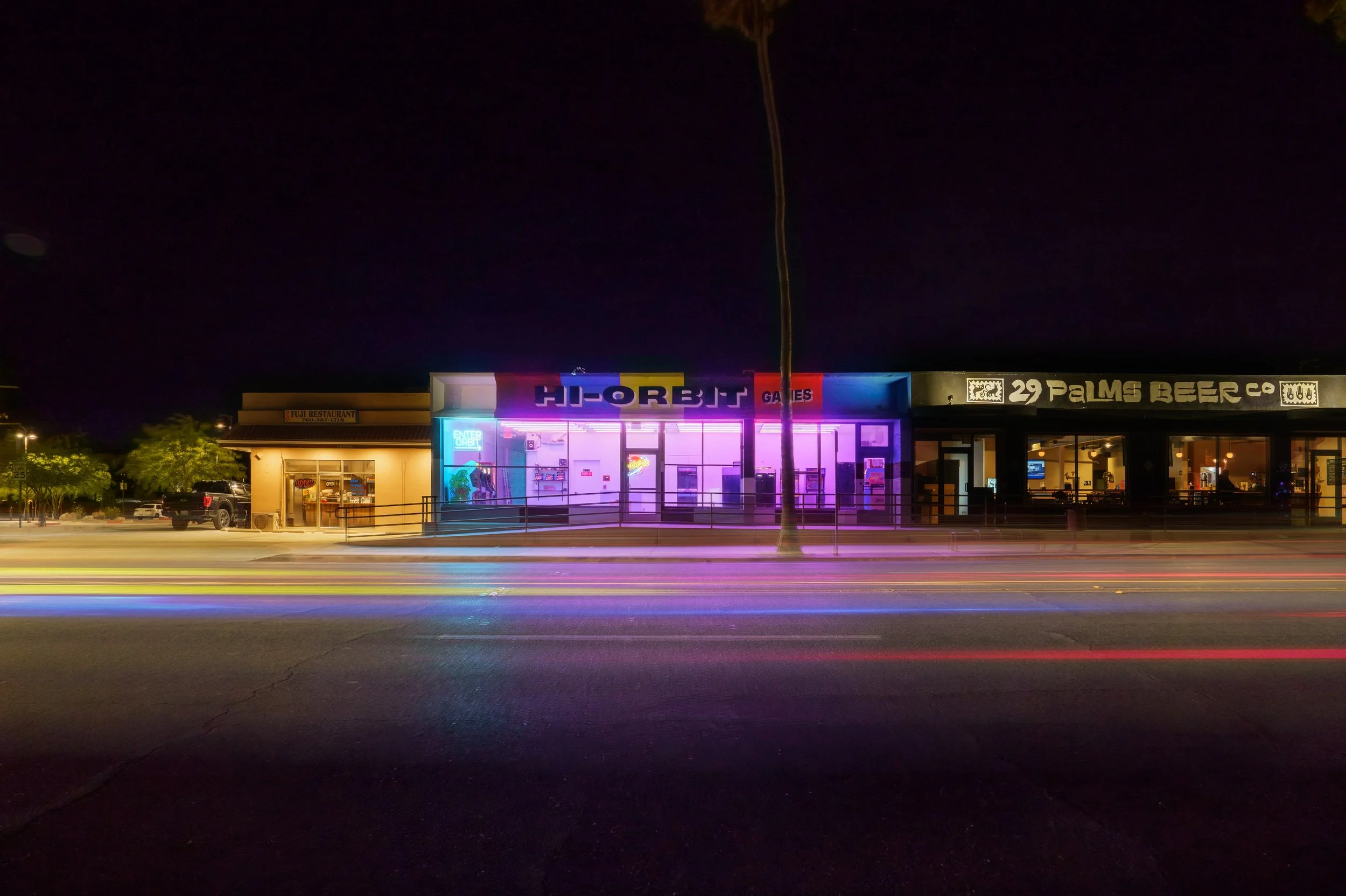 Hi-Orbit Games Exterior at Night with Light Trails on the Street