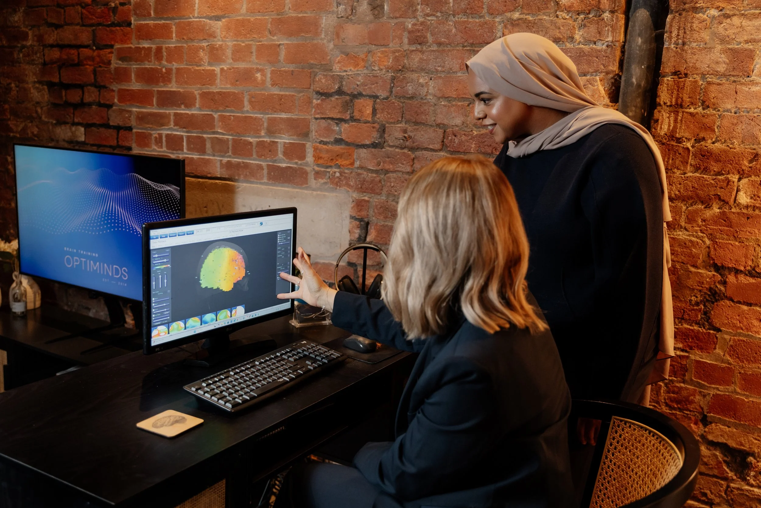 two women analysing a QEEG brain map