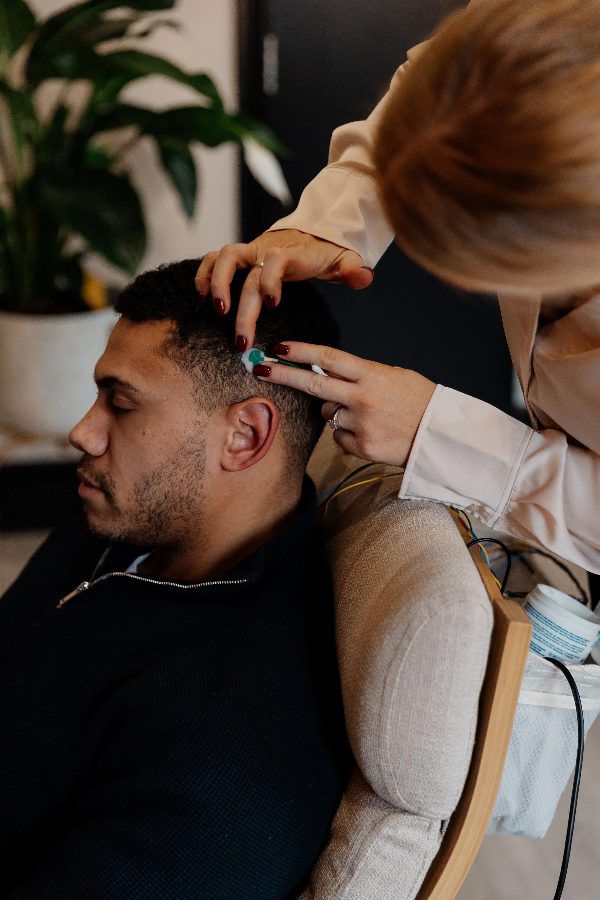 applying EEG sensors to male client during neurofeedback
