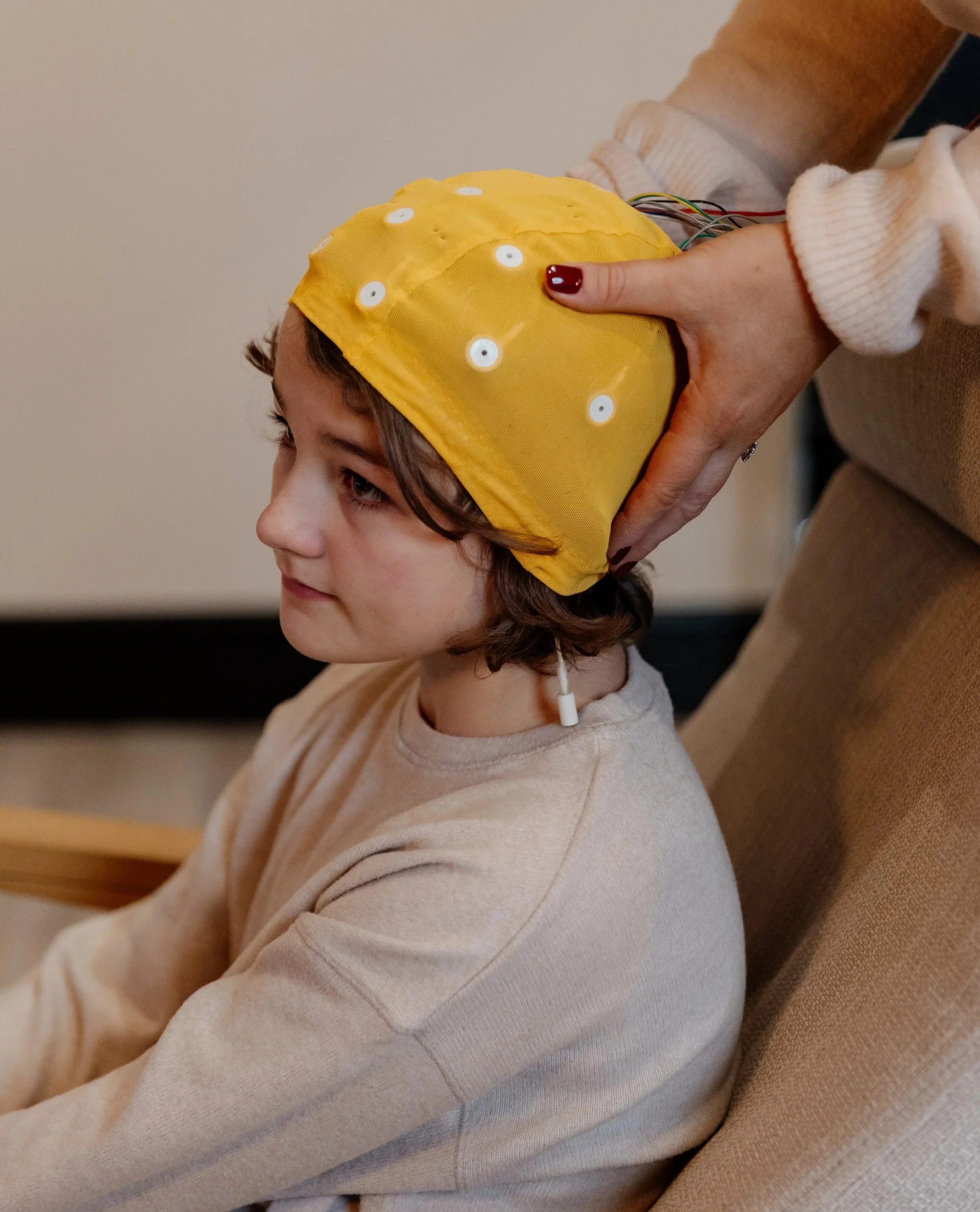 a teenager wearing an EEG cap, looking relaxed