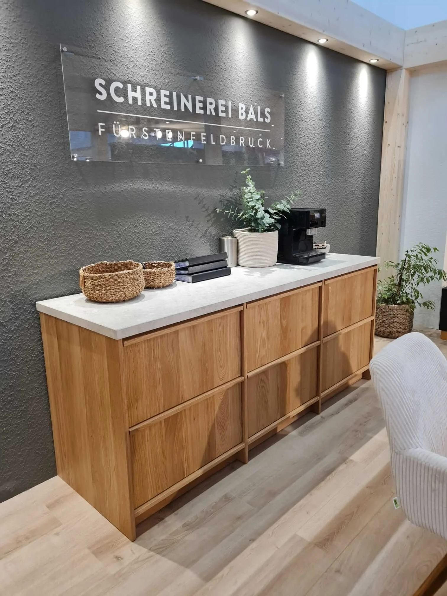  Eiche-Sideboard mit Logo-Schild am Messestand, Halle B5 Stand 101. 