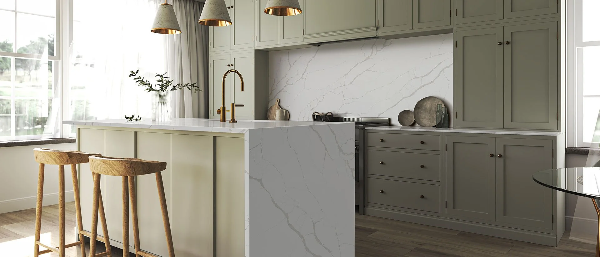 Modern kitchen with gray cabinets, white marble backsplash, a white marble island with a gold faucet, and two wooden bar stools.