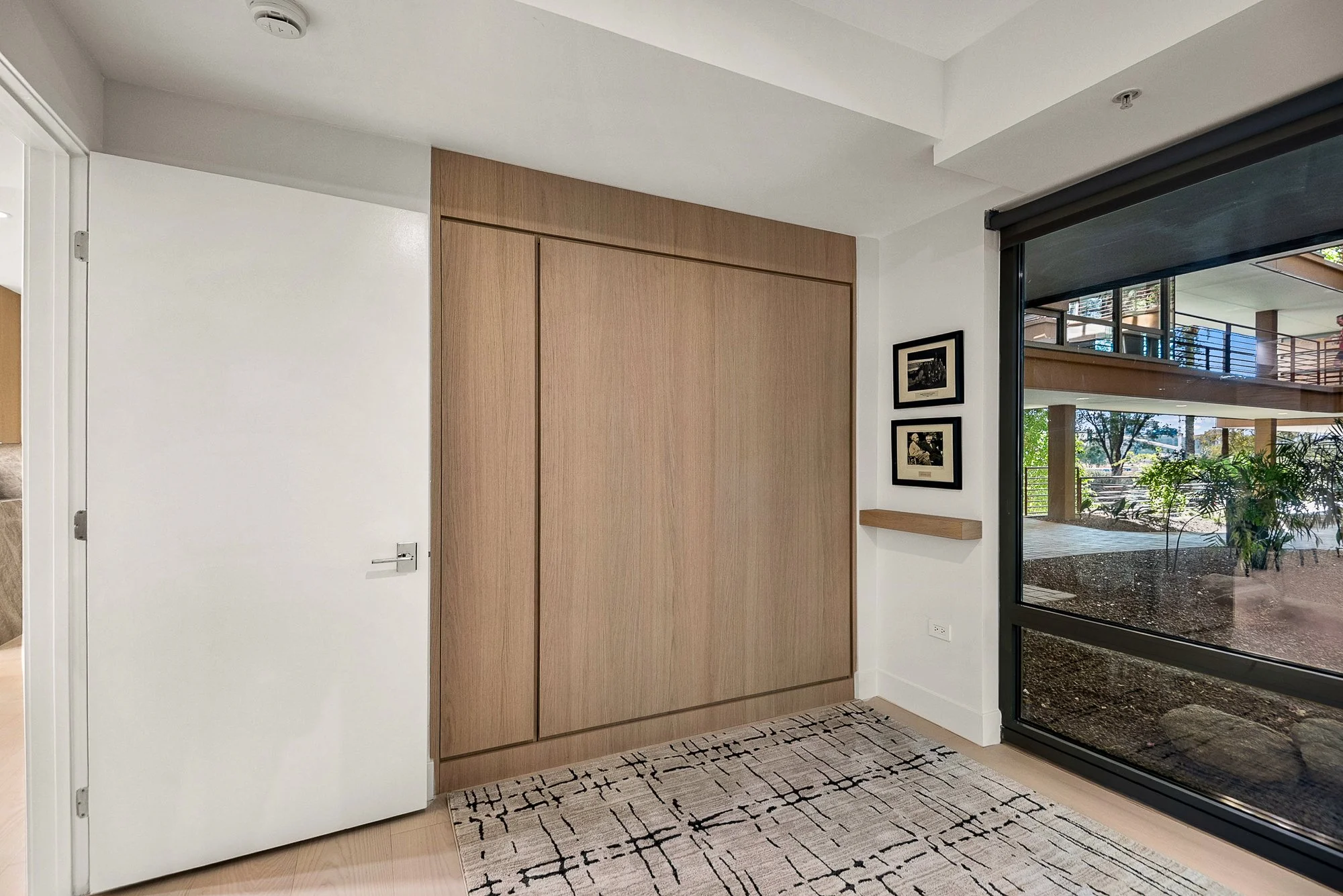 Modern minimalist white oak murphy bed to provide extra bed in a home office