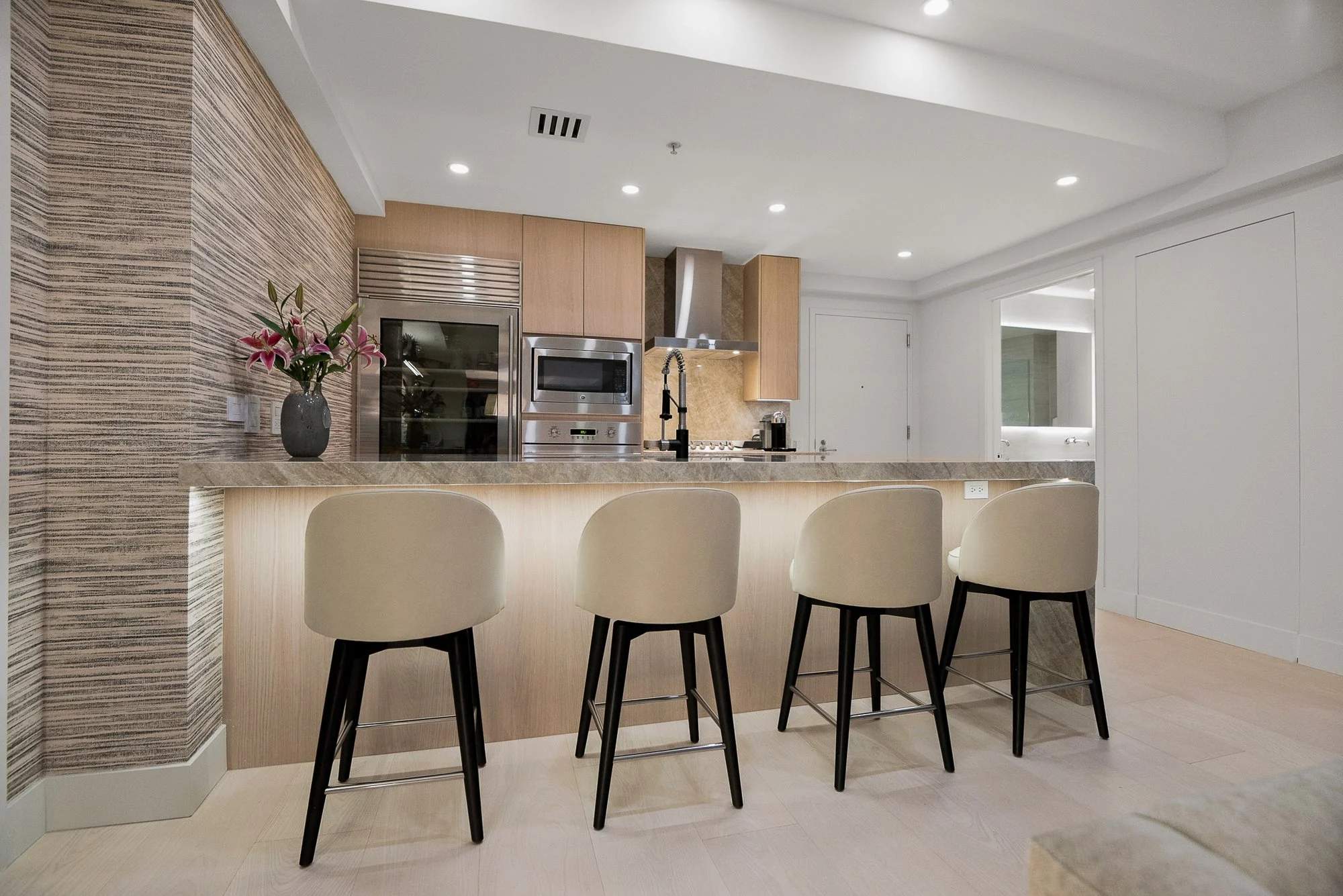 Modern living room with brown leather sofa, fireplace, minimalist decor, and open dining area leading to garden.
