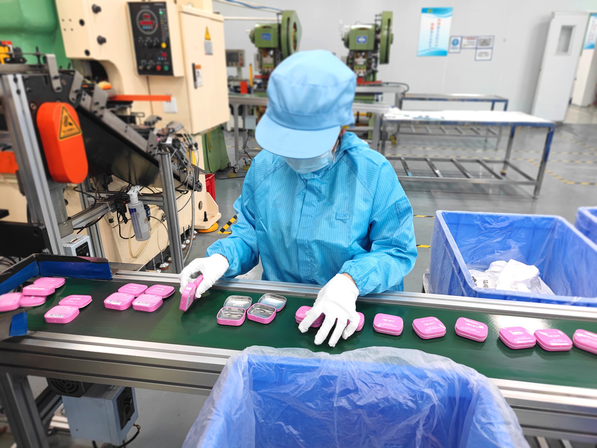 In our cleanroom, our quality inspectors are wearing protective hygiene suits and carefully inspecting each tin box to ensure product quality.