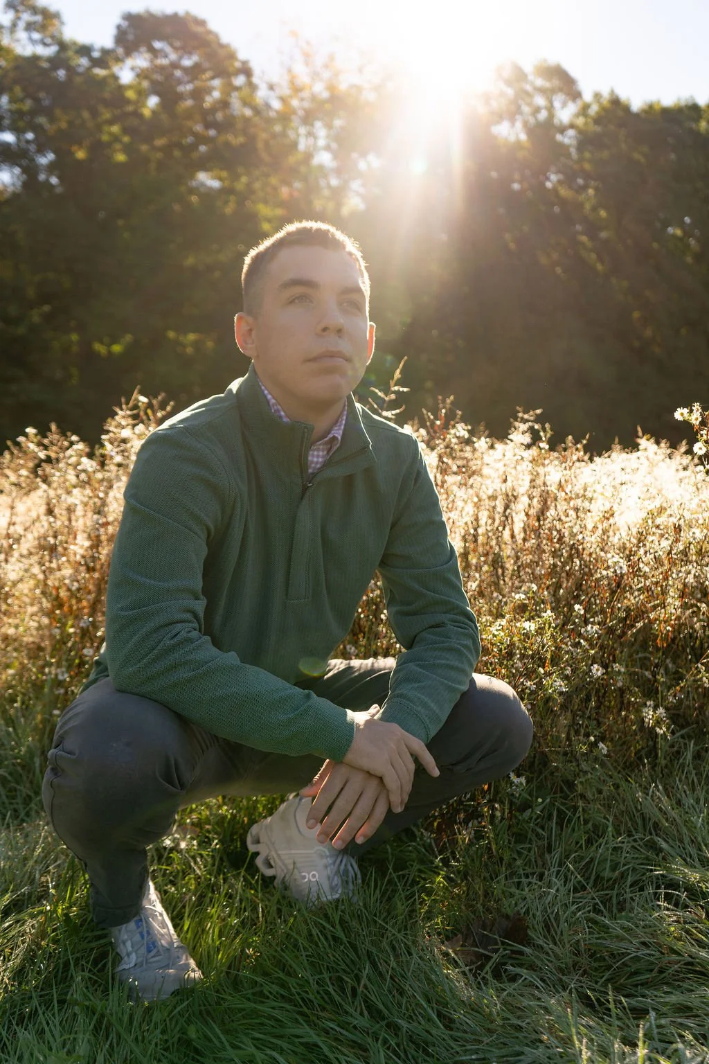 Fall senior pictures in Cuyahoga Valley National Park, with a young man seated in sunlit grass