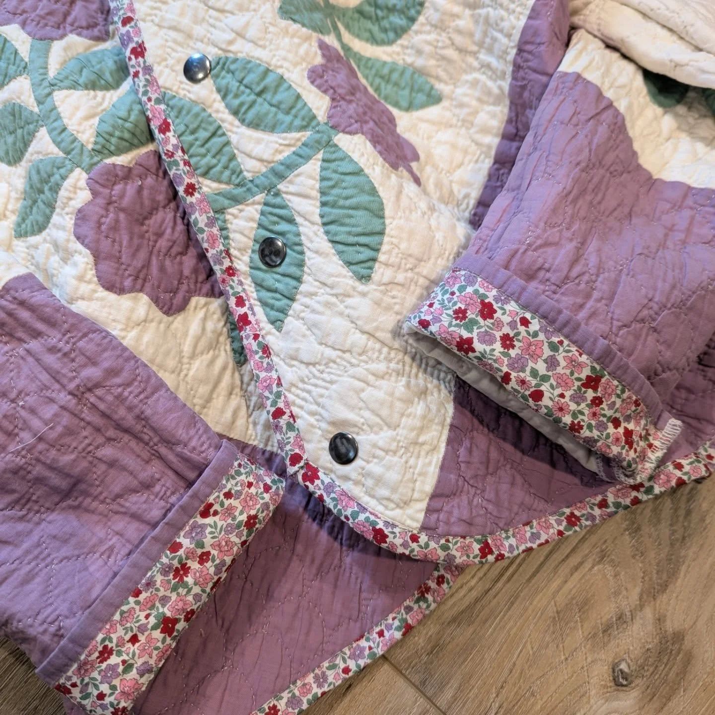 This cute floral fabric has made at least half a dozen moves with me. It's from a small shop in the heart of Fabric Town in Nippori, Japan. The colors are perfect for this quilt, and I am loving the accent on the inside of the cuffs!💜💚🩷❤️

details
