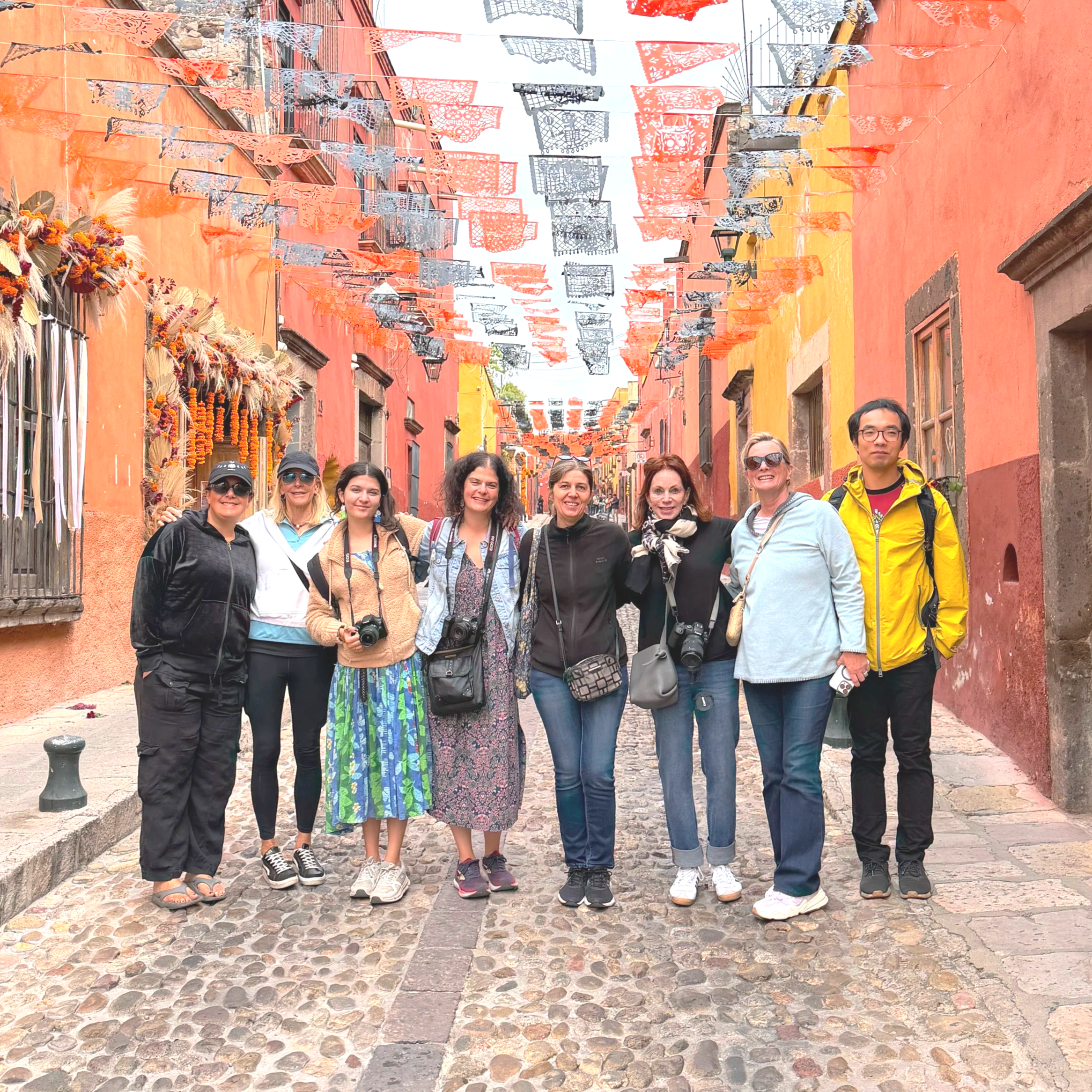 Small group of adults on a photography tour in a colorful street, part of Art of Intuitive Photography’s creative travel retreats and skillcations