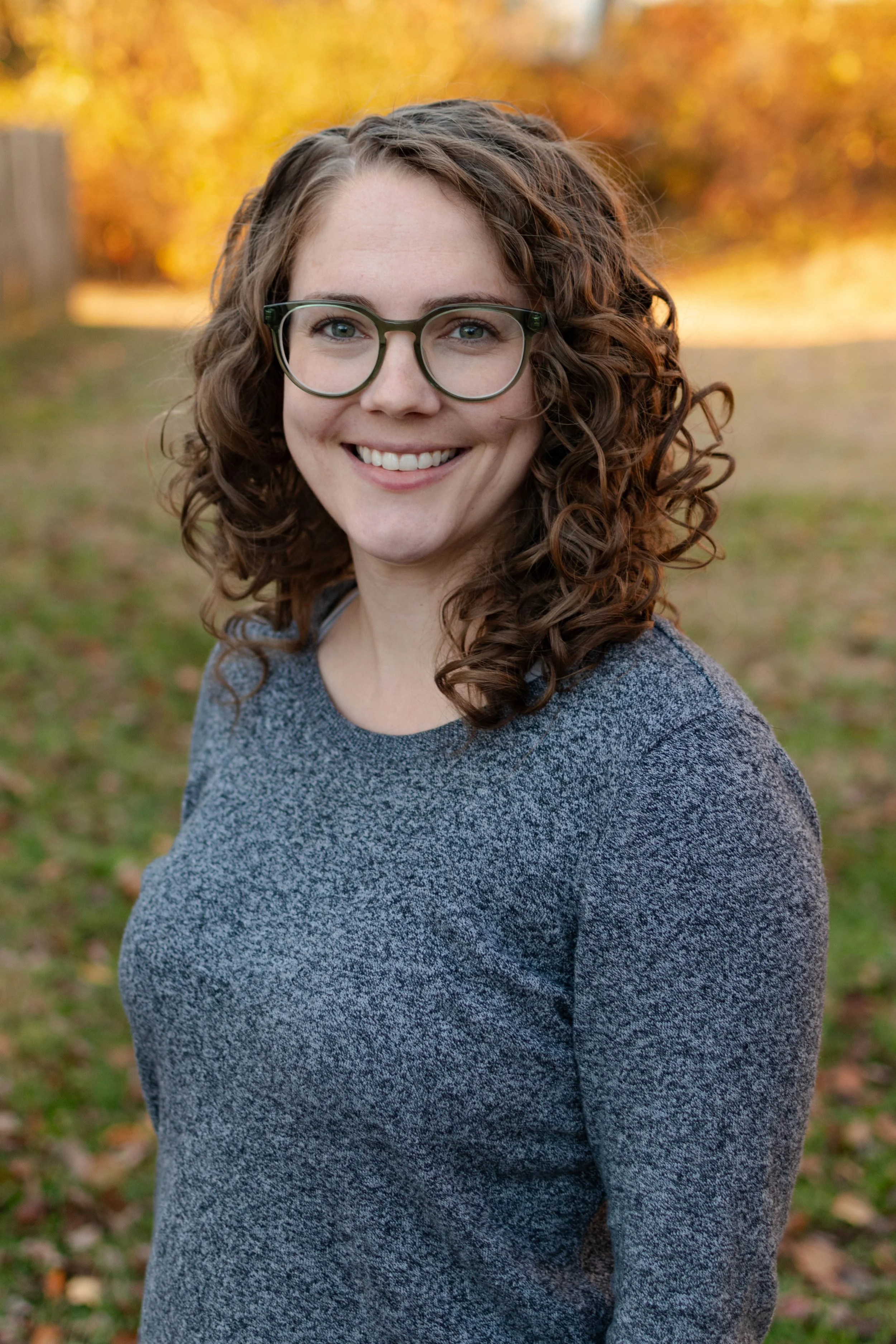 Image of Dr. Amy Smith smiling facing the camera with fall colors in the background