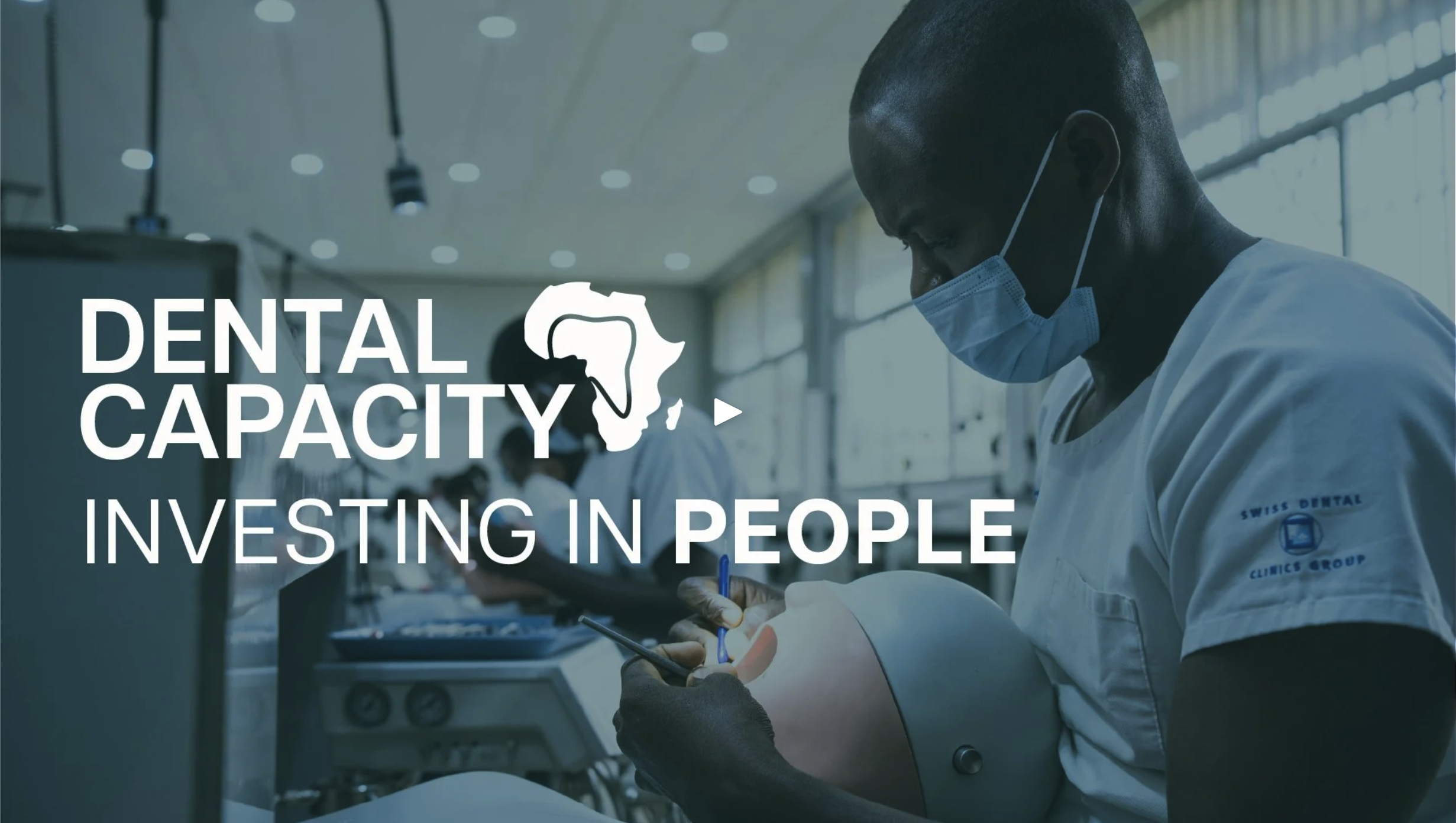 A dentist in a white coat and face mask examining a dental model while working on a tablet in a modern dental clinic, overlaid with text about investing in people's dental capacity.