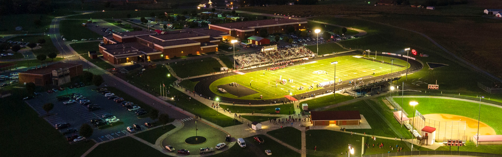Aerial view of a packed high school football stadium at night in Rockingham County, Virginia.