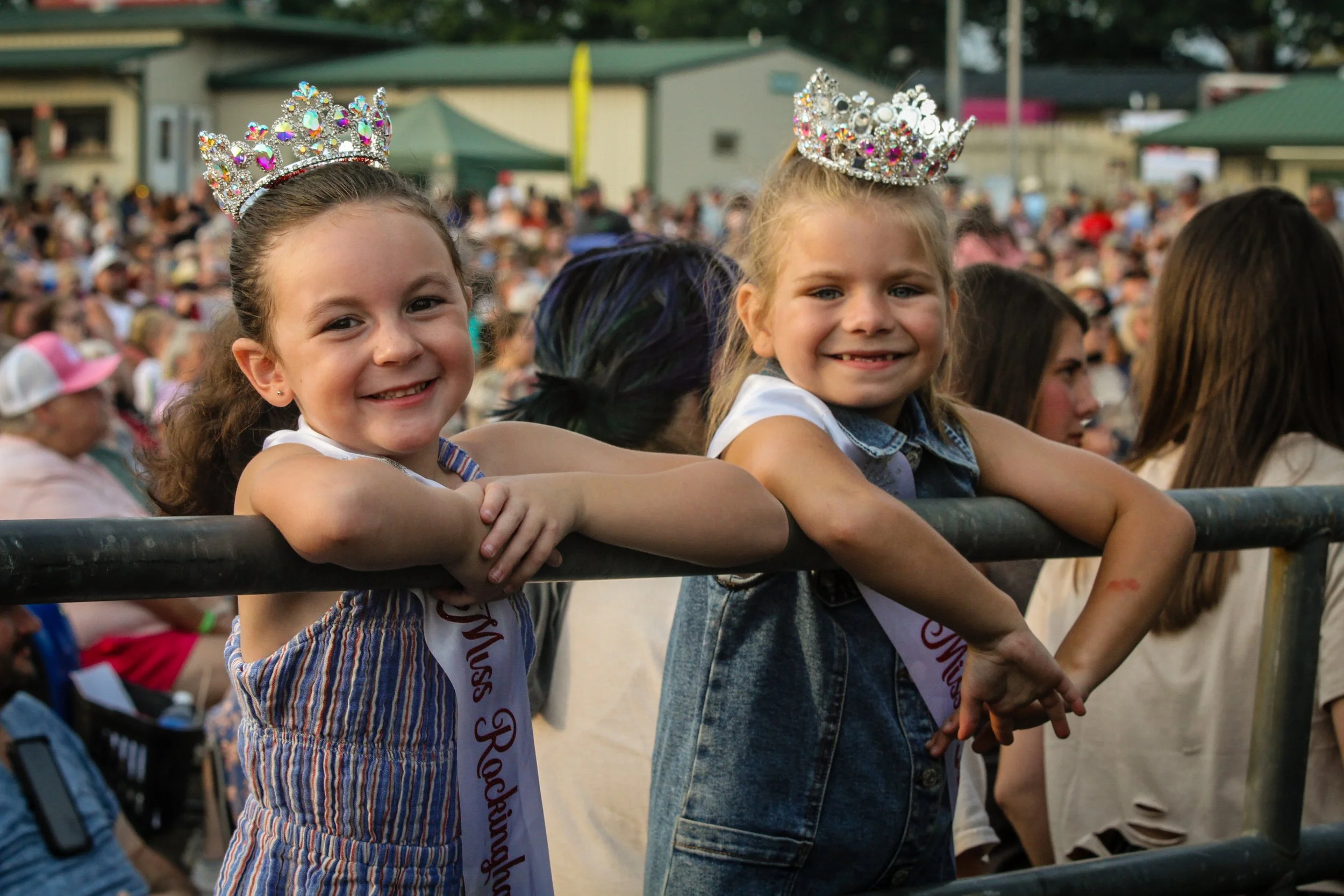 two young girls smiling with their miss rockingham county tiaras and sashes