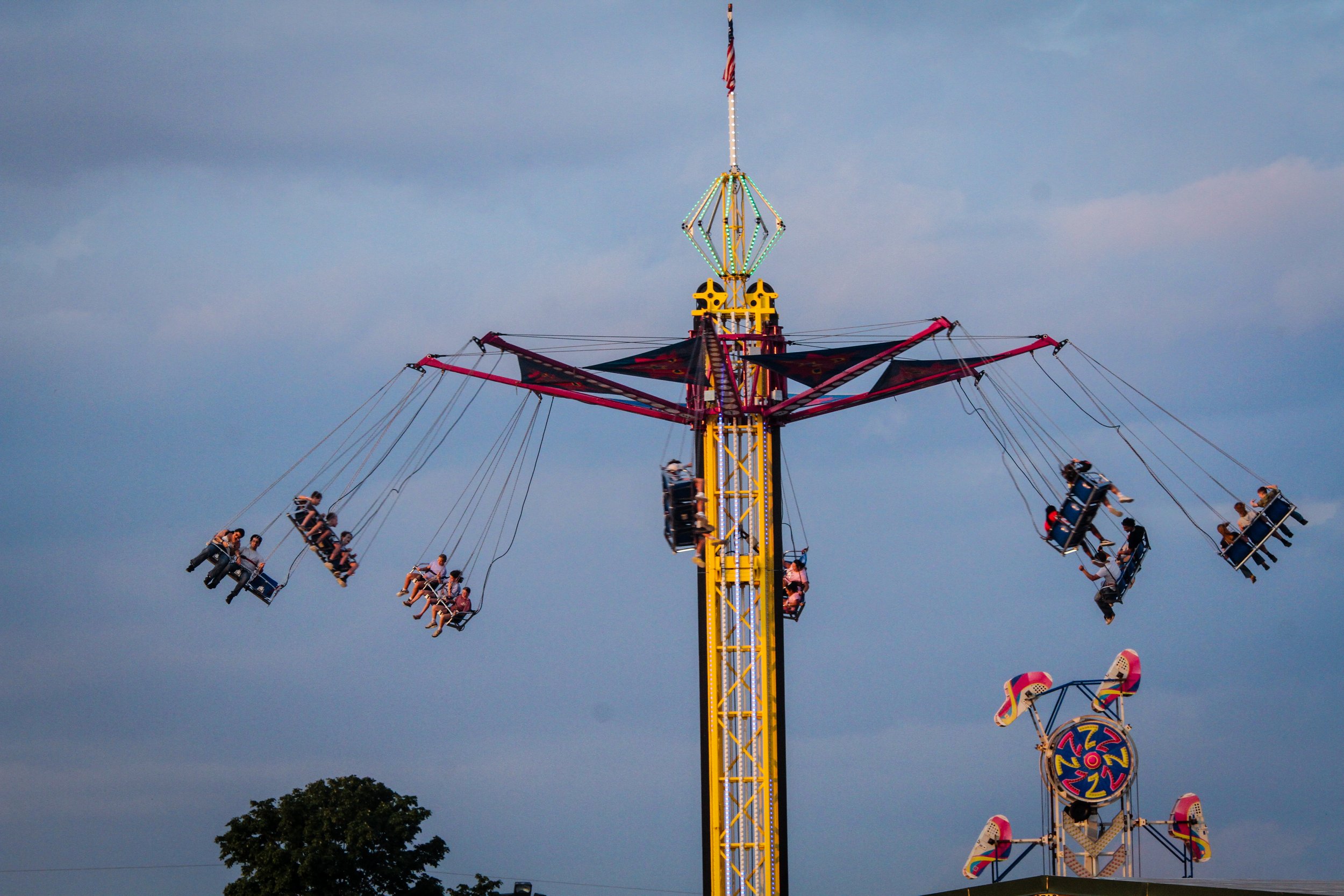 a carnival ride up and running with people swinging in the air