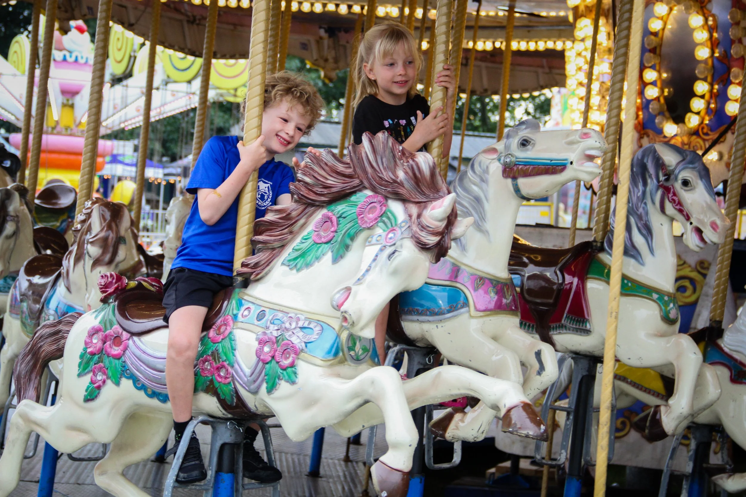two kids riding on the carousel