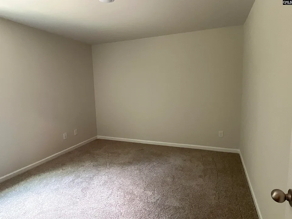 Empty room with beige carpet and light-colored walls.