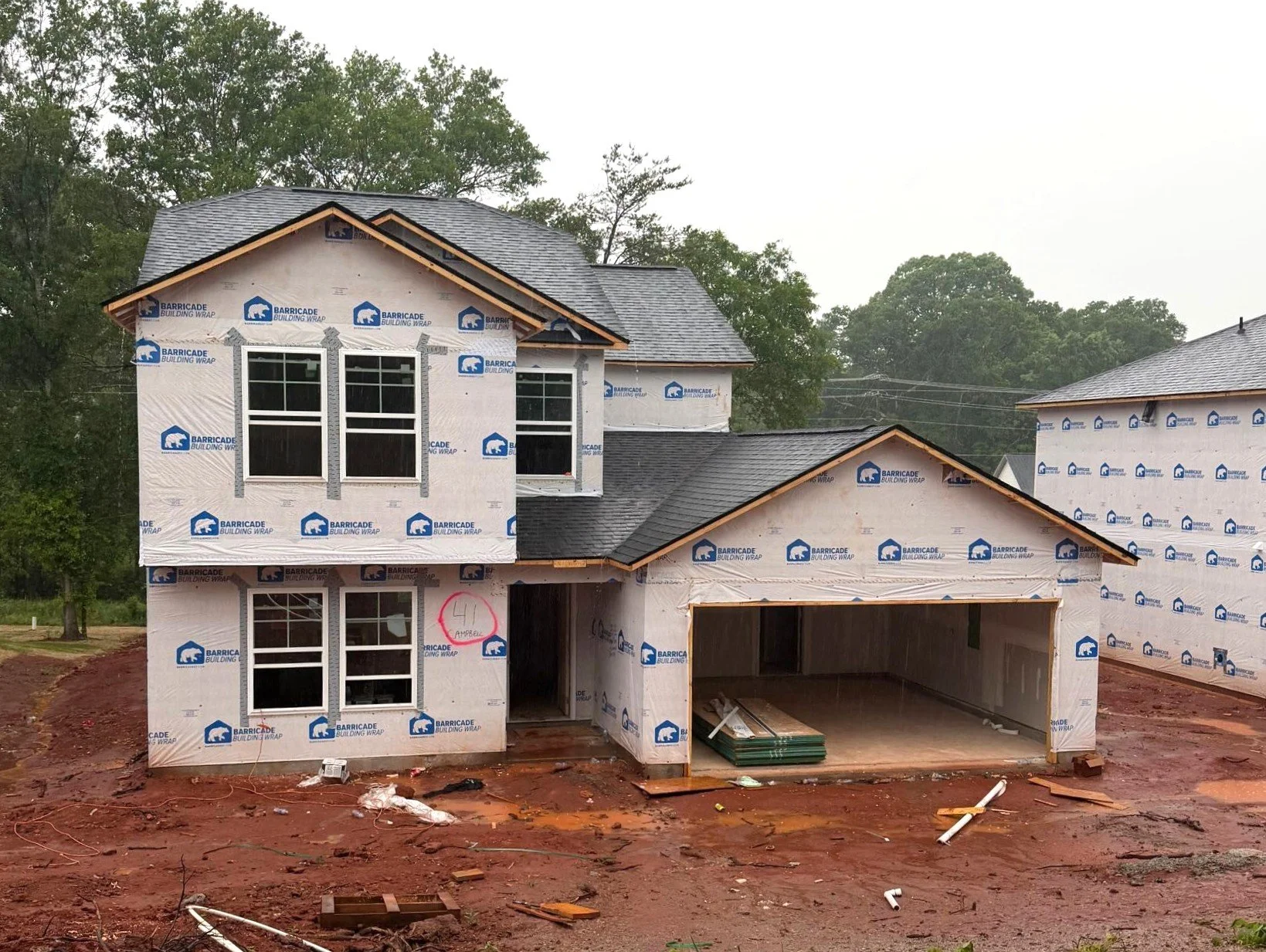 Line drawing of a two-story house with a garage, front door, and multiple windows.