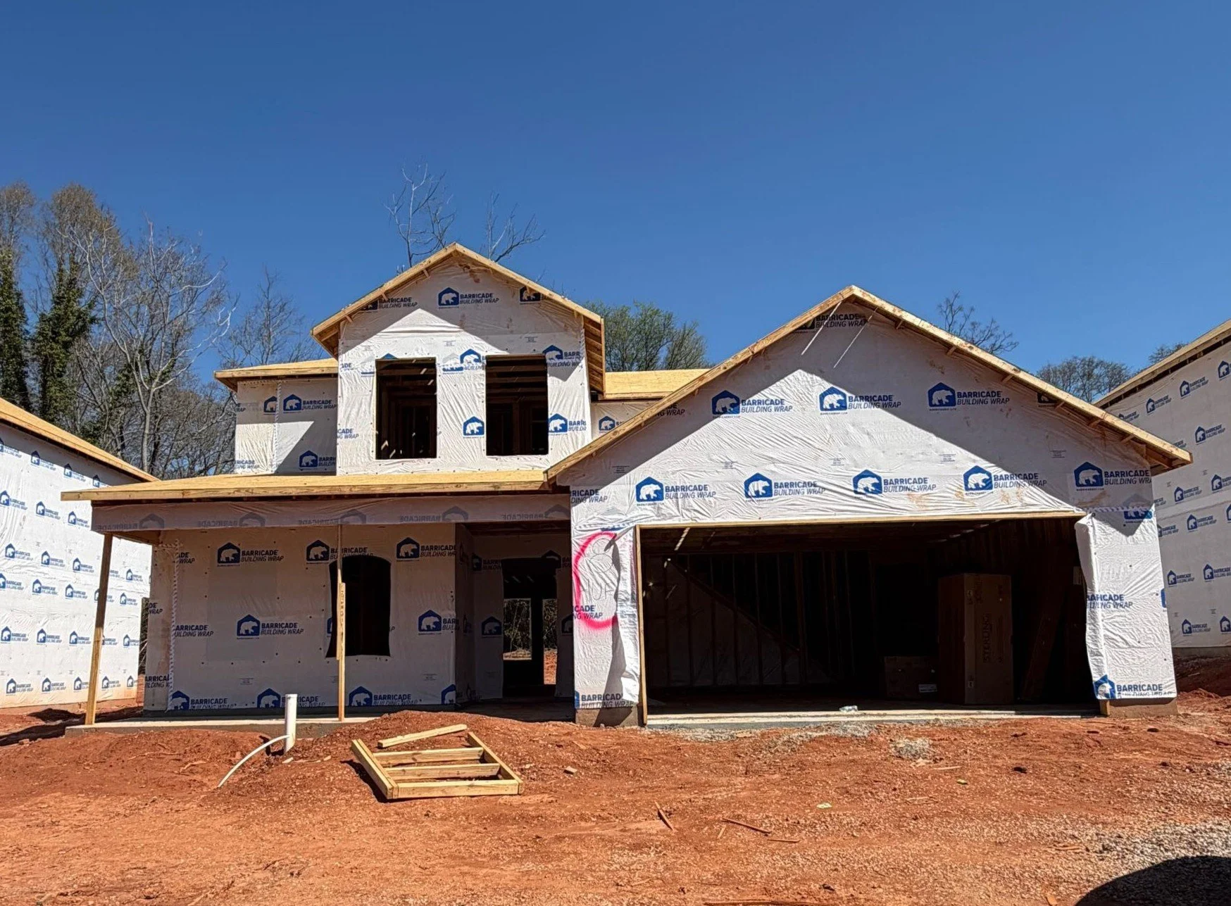 Architectural blueprint of a two-story house with a attached garage, front door, multiple windows, and detailed roof design.