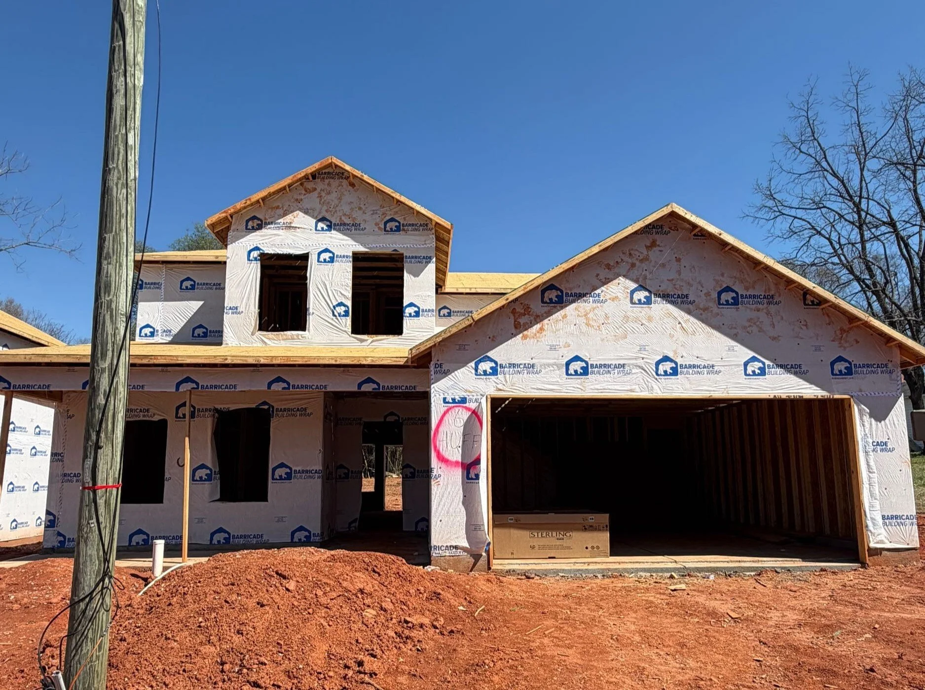 Line drawing of a two-story house with multiple windows, a front door, and an attached garage.