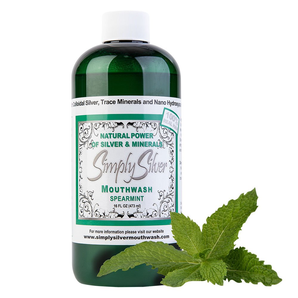 Bottle of Simply Silver mouthwash labeled spearmint flavor with fresh mint leaves in front.
