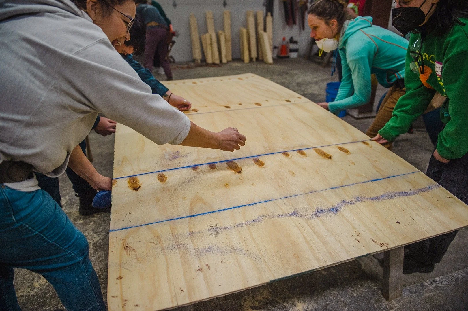 You don't have to struggle with a straight edge. Try using a chalk line! This tool is well-known by carpenters but underused by DIYers. It's been around for thousands of years, famously used by ancient Egyptians to mark gridded lines for layout of wa