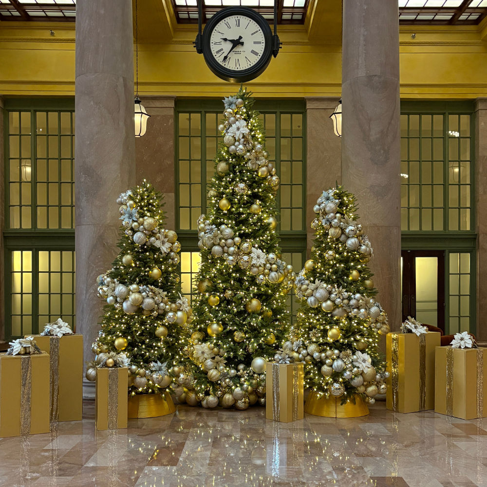 Commercial holiday tree display at Union Depot St. Paul featuring three towering Christmas trees with gold and silver ornaments.