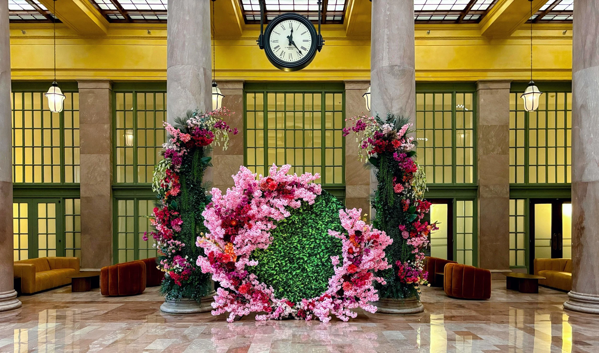 Commercial spring seasonal styling featuring a vibrant pink floral circle and matching columns for a photo-op at Union Depot.