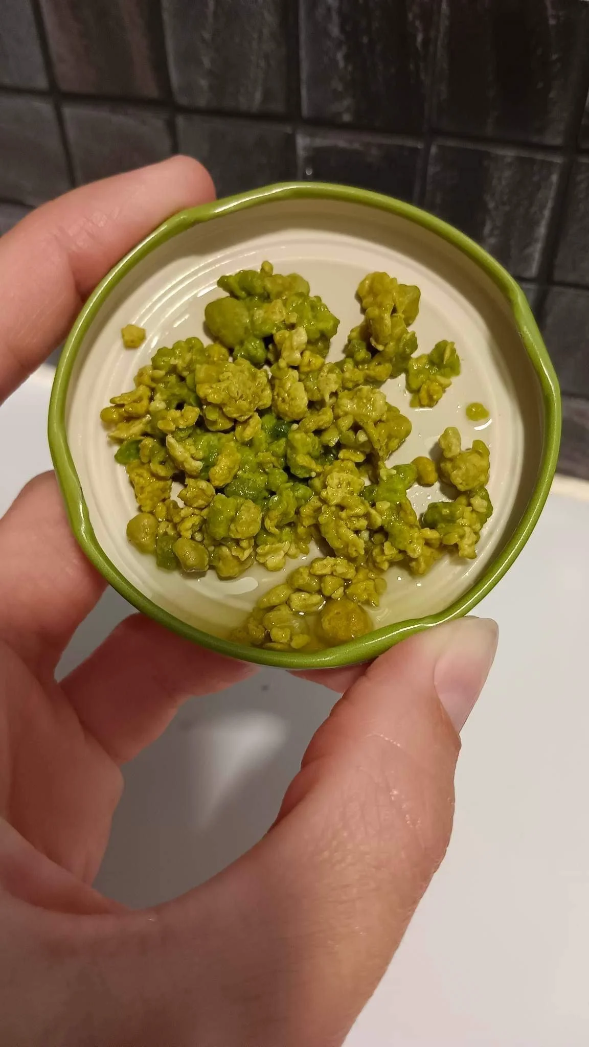 Image of Woman's Hand holding a bottle top full of real bright green gallstones released during a liver gallbladder cleanse with Nik Heartsong Winged Heart Healing