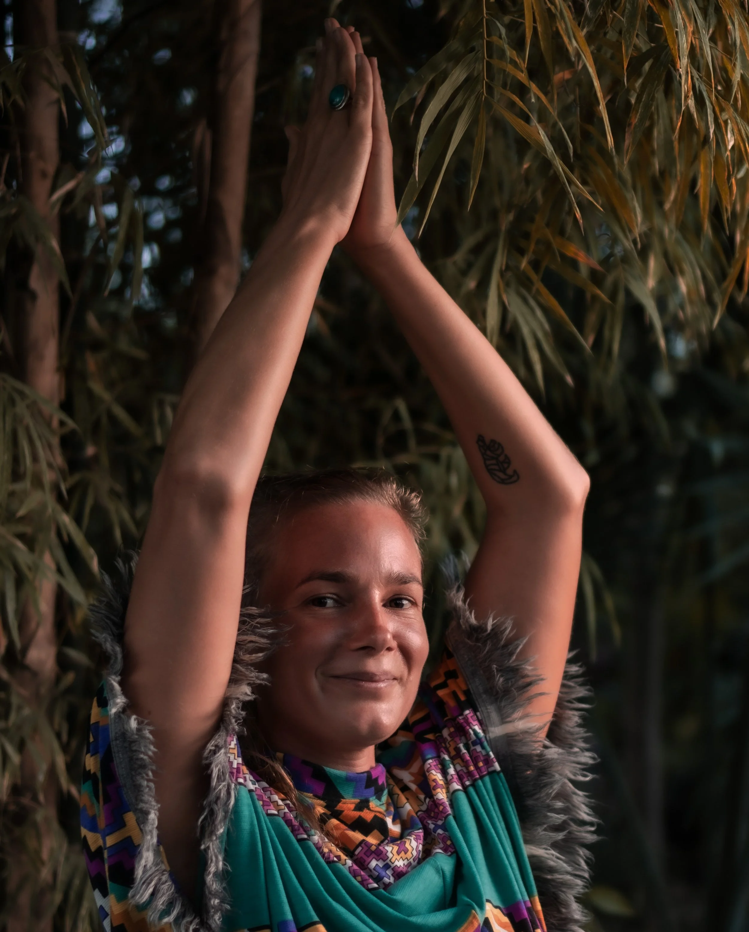 Nik heartsong Winged Heart Healing Bioresonance Therapist and Holistic Detox Coach with her hands in prayer above her head root cause healing what's possible