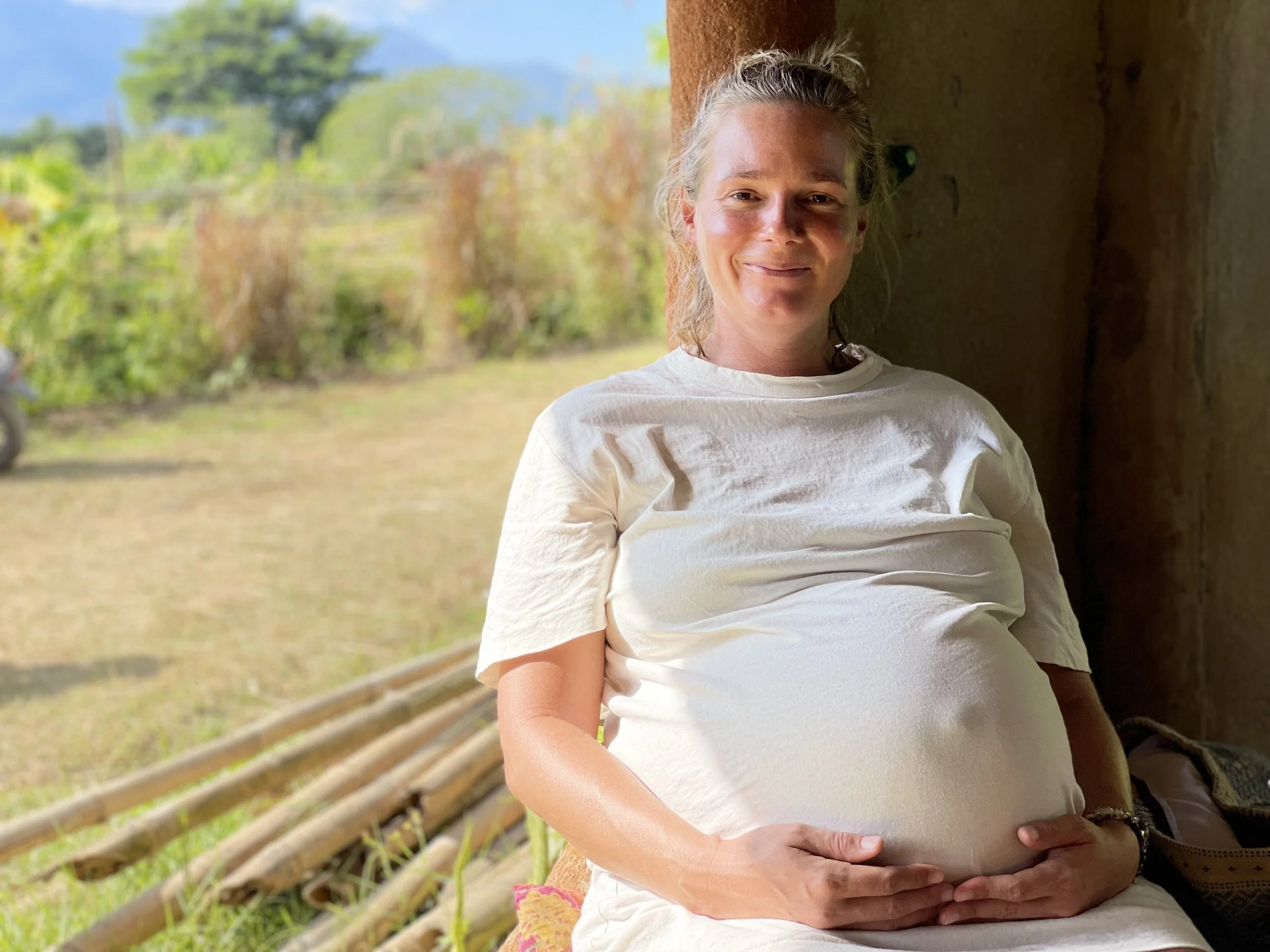 Nik Heartsong 9 months pregnant with second child Rio in Pai Thailand with a view of the sun kissed rice fields root cause healing with Winged Heart Healing