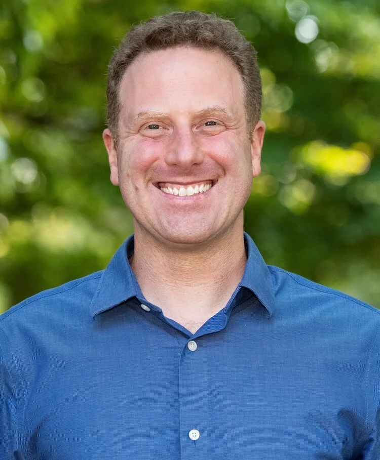 Headshot of Josh Balk wearing a blue button down and smiling.