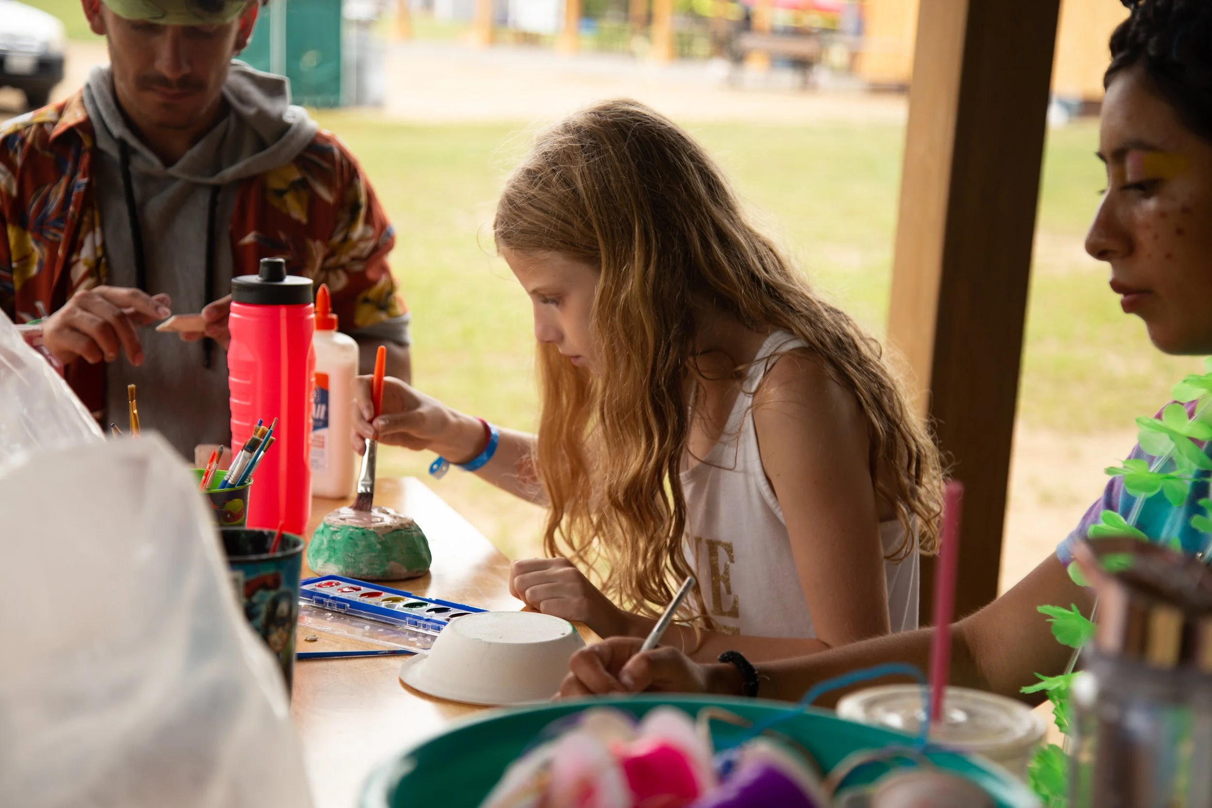 Campers enjoying ceramics outside.
