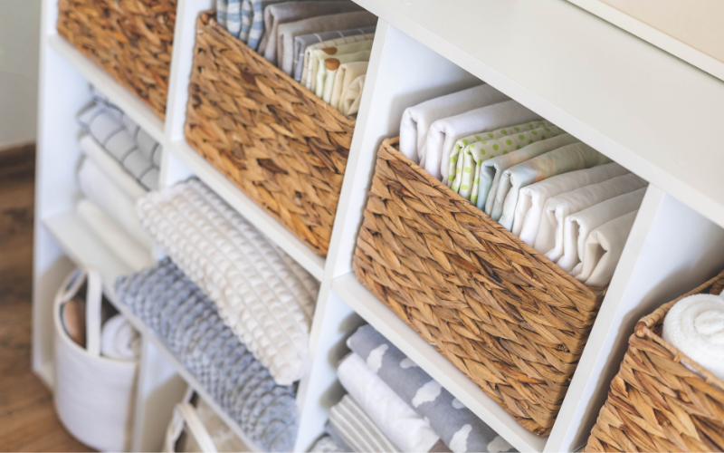 Wicker baskets and folded linens organized on open shelving