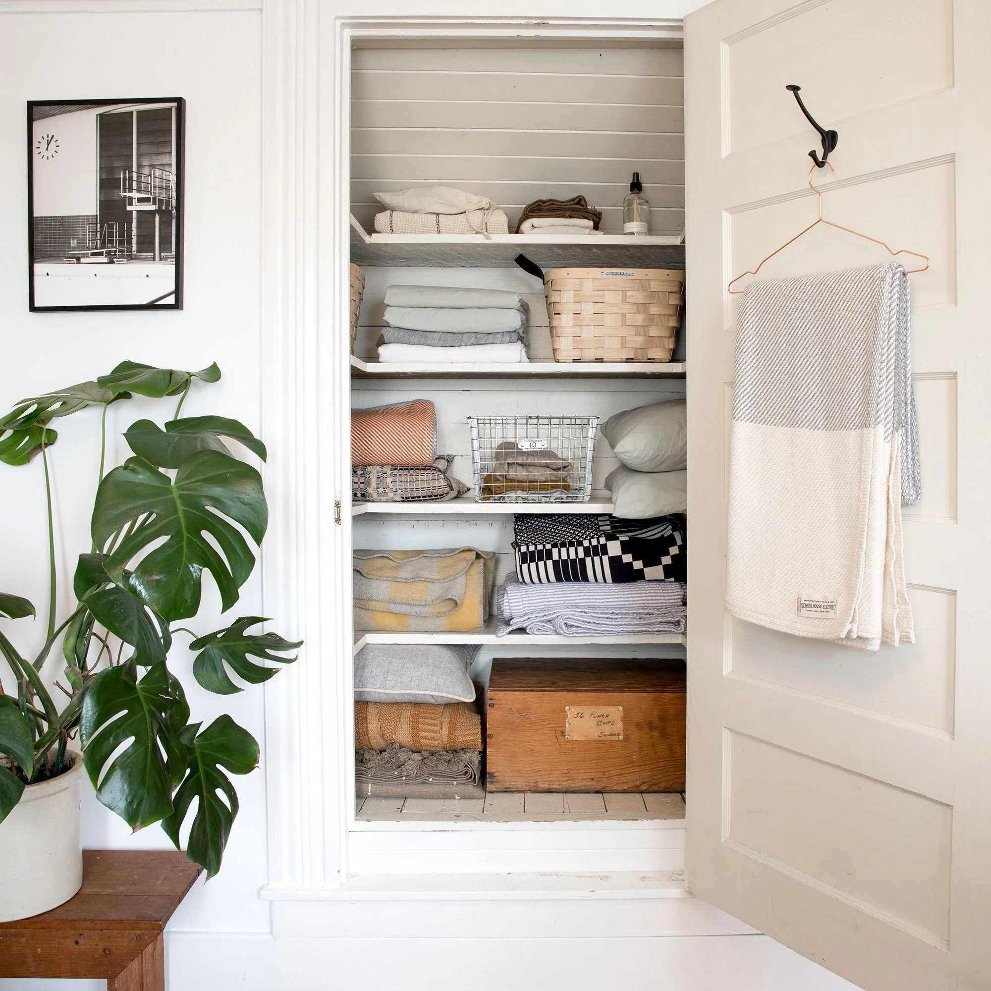 Organized home shelving with woven baskets, plants, and functional storage