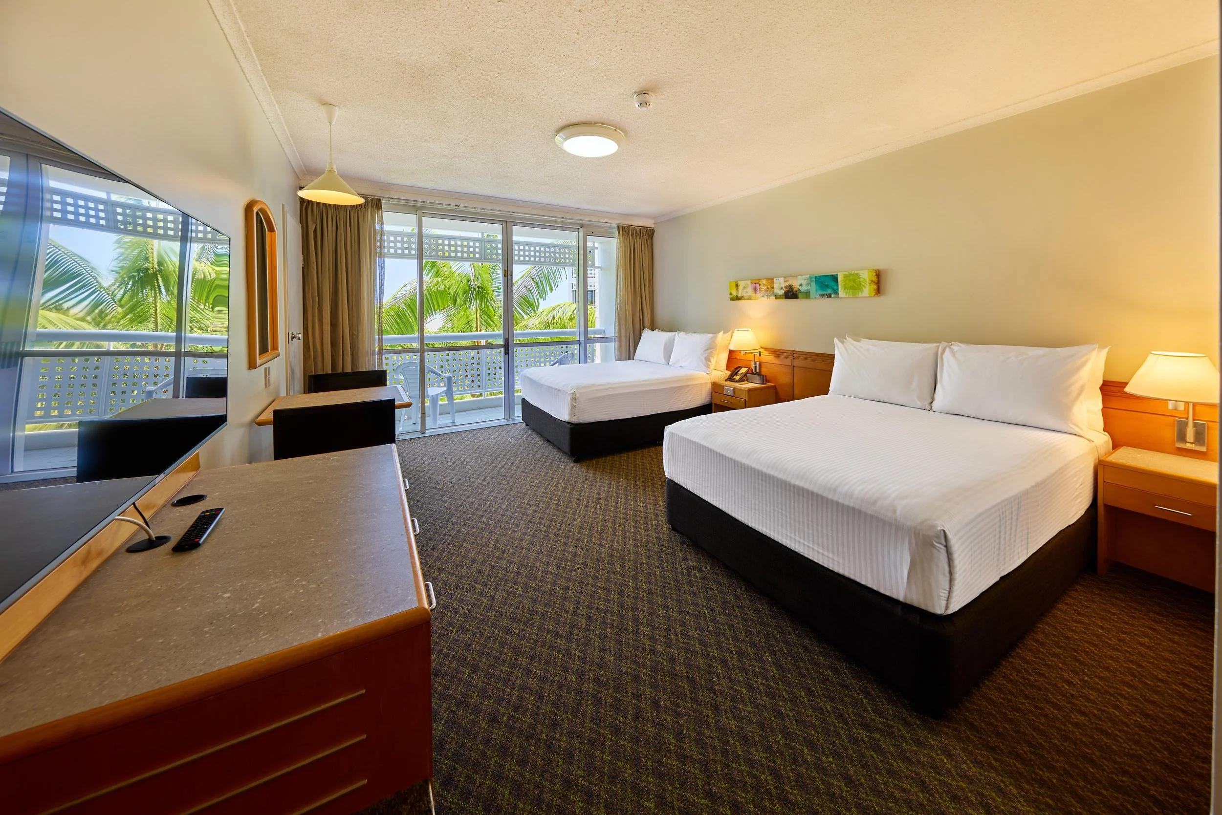 Two double beds with bedside tables overlooking private balcony.jpg