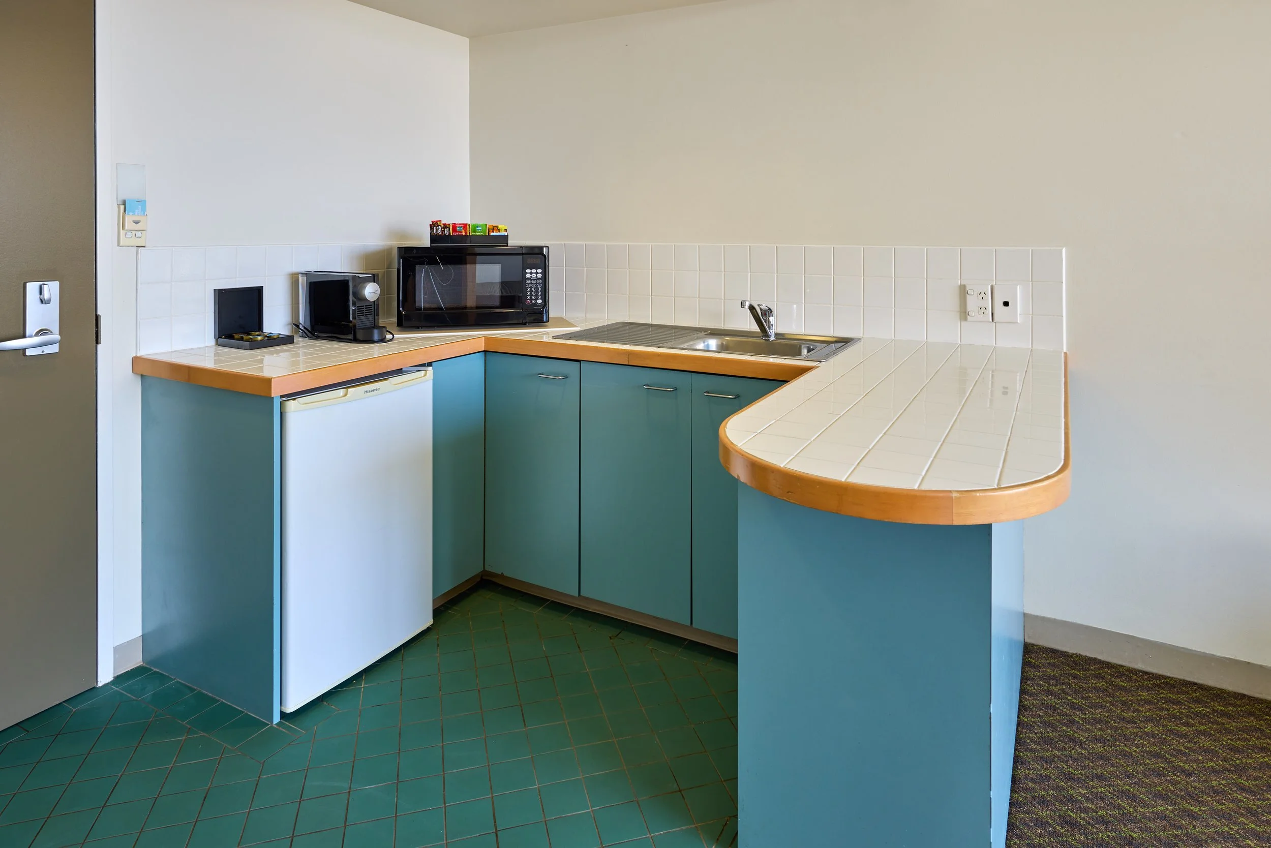 Kitchenette with microwave, sink, coffee machine and coffee pods.jpg