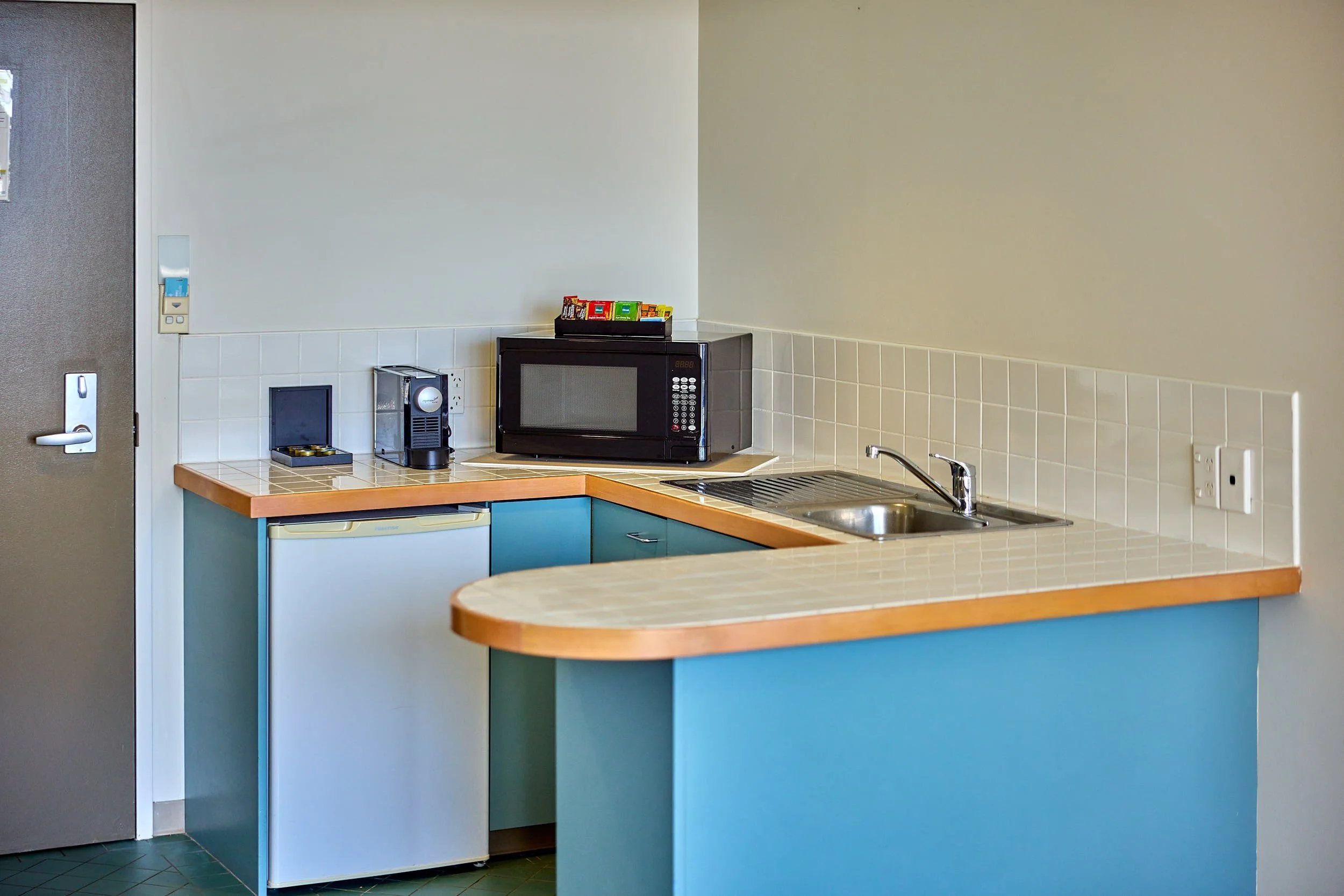 Kitchenette with sink, microwave, coffee machine and coffee pods.jpg