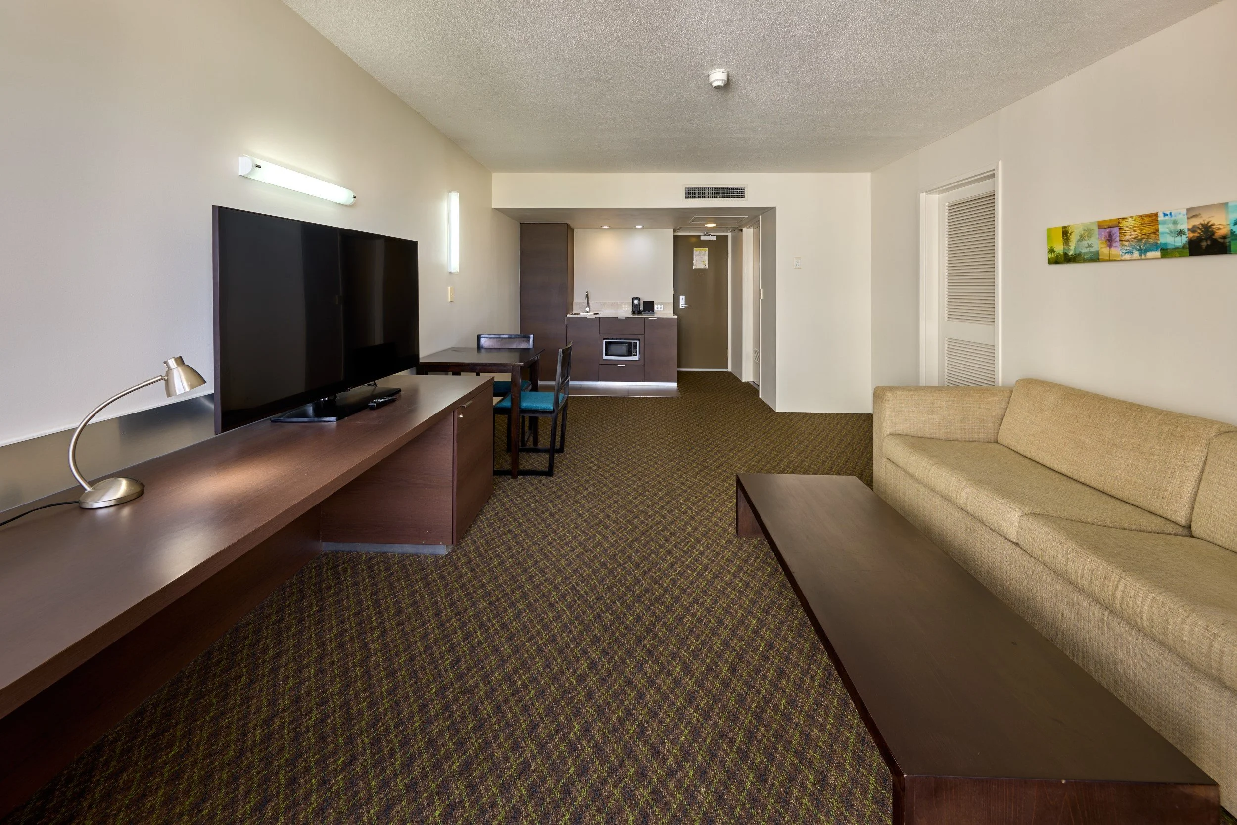 Separate living area with double sofa, coffee table, smart TV, dining table with 2 chairs and kitchenette (2).jpg