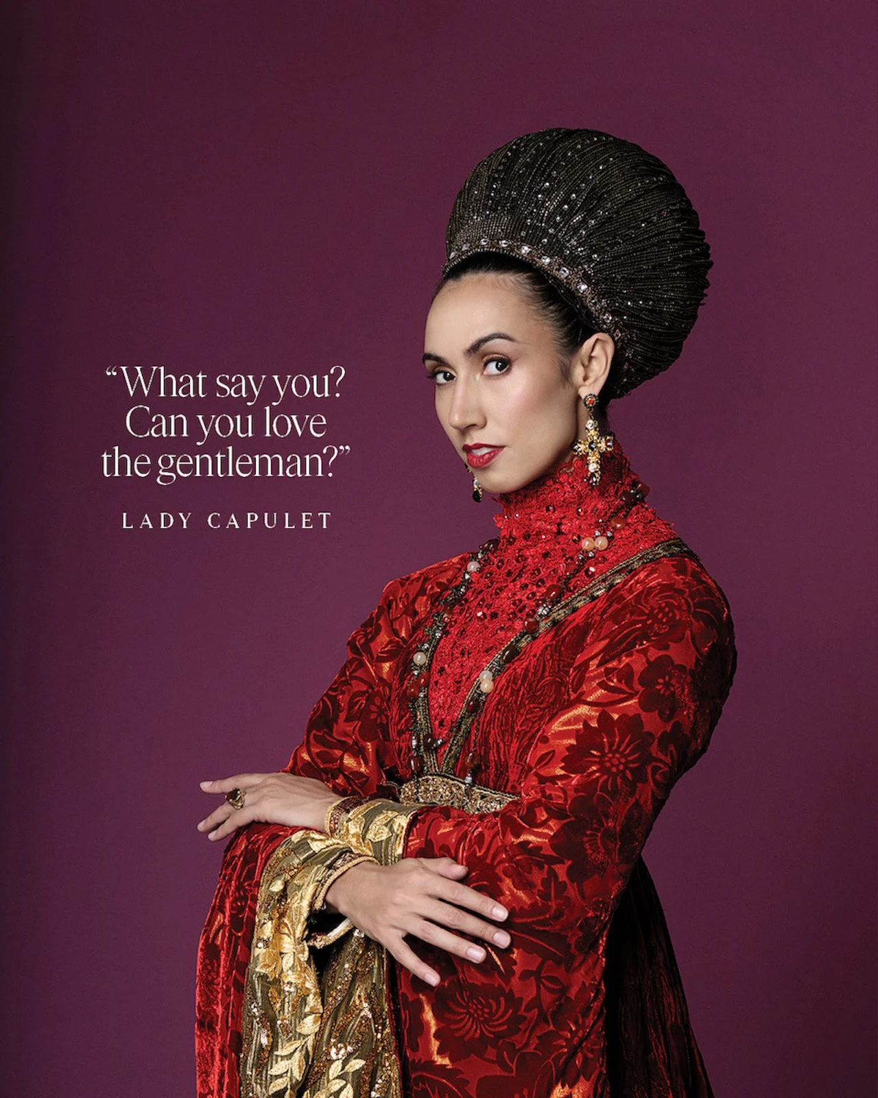 A woman dressed in an elaborate red and gold costume with intricate jewelry, standing with arms crossed, against a purple background. Text on the image quotes Lady Capulet from Shakespeare's Romeo and Juliet and reads, "What say you? Can you love the