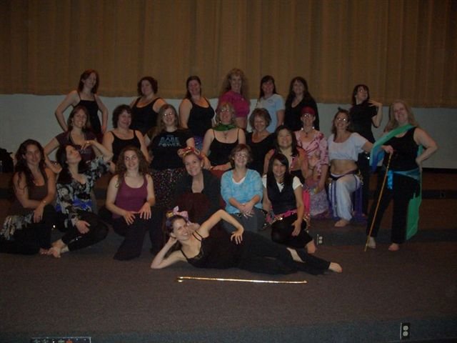 About 22 students pose for a photo at the end of a Saidi cane dance workshop. Lara poses front and center with a Saidi cane.