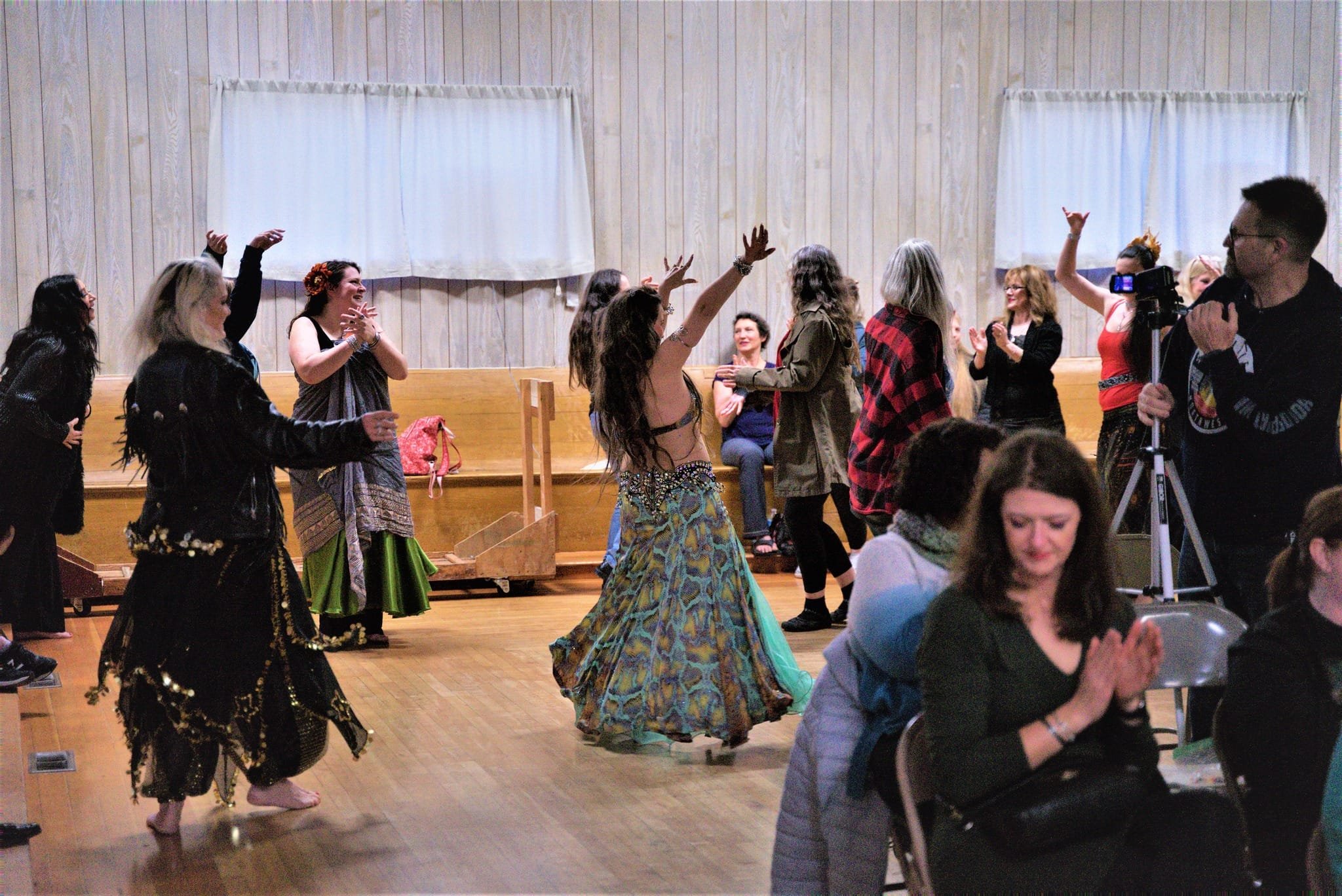 Lara Victoria dances in the middle of the audience at the end of her featured performance. She is wearing a turqoise, purple and gold snakeskin patterned costume.