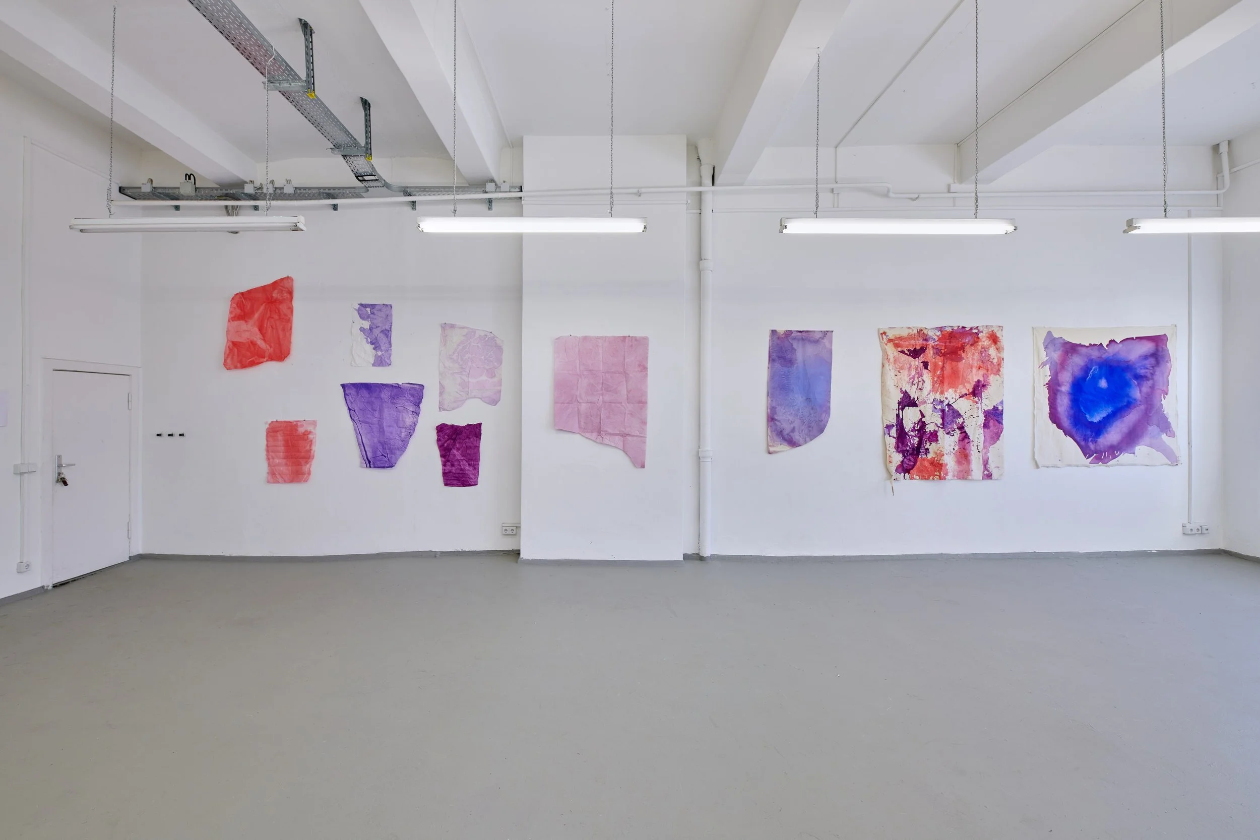 Installation view of Marie Birkedal’s Godspeed / Savage Glitter, with colourful works on paper and unstretched cotton across the gallery walls