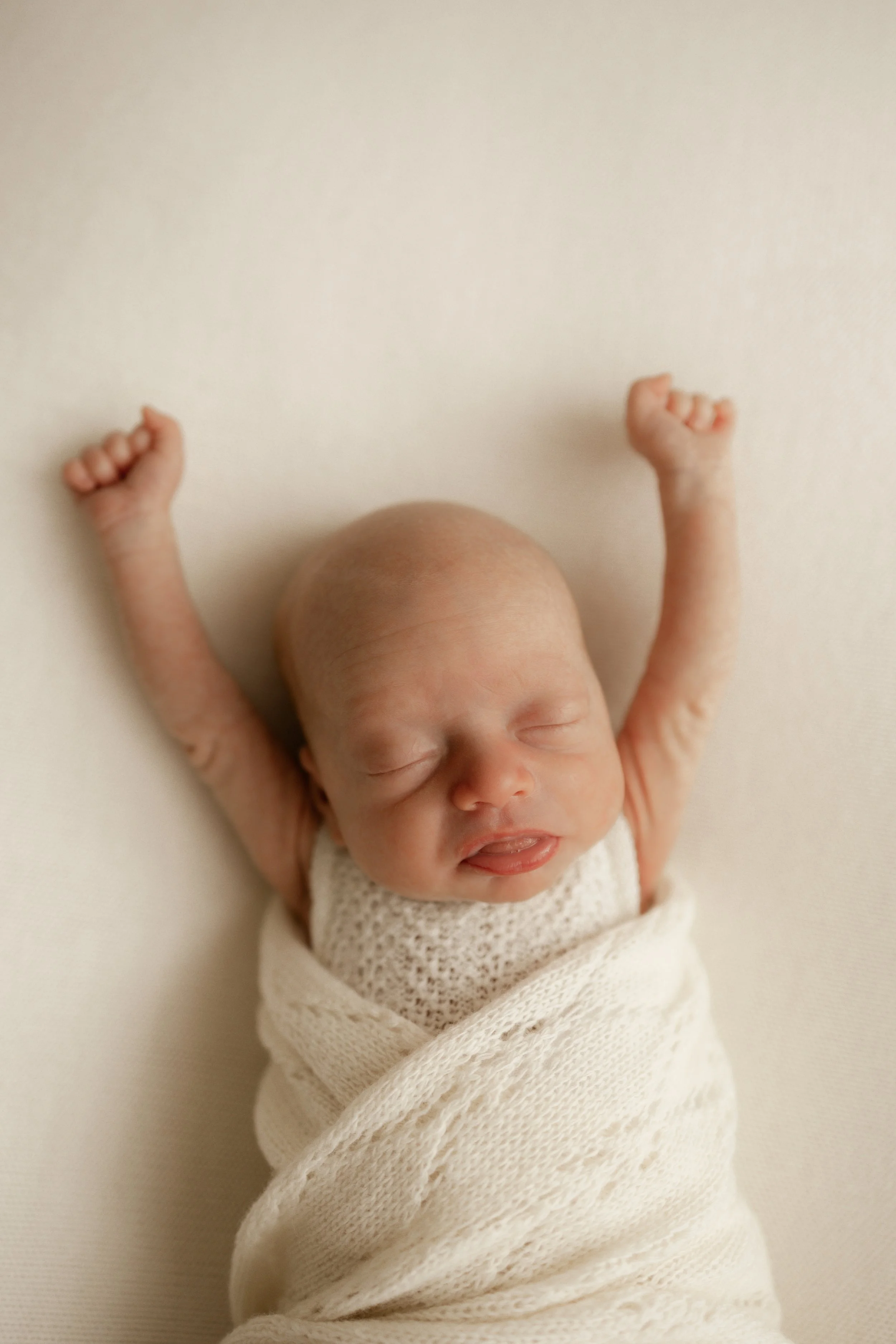 week old baby stretching whilst taking a nap in my natural light studio 
